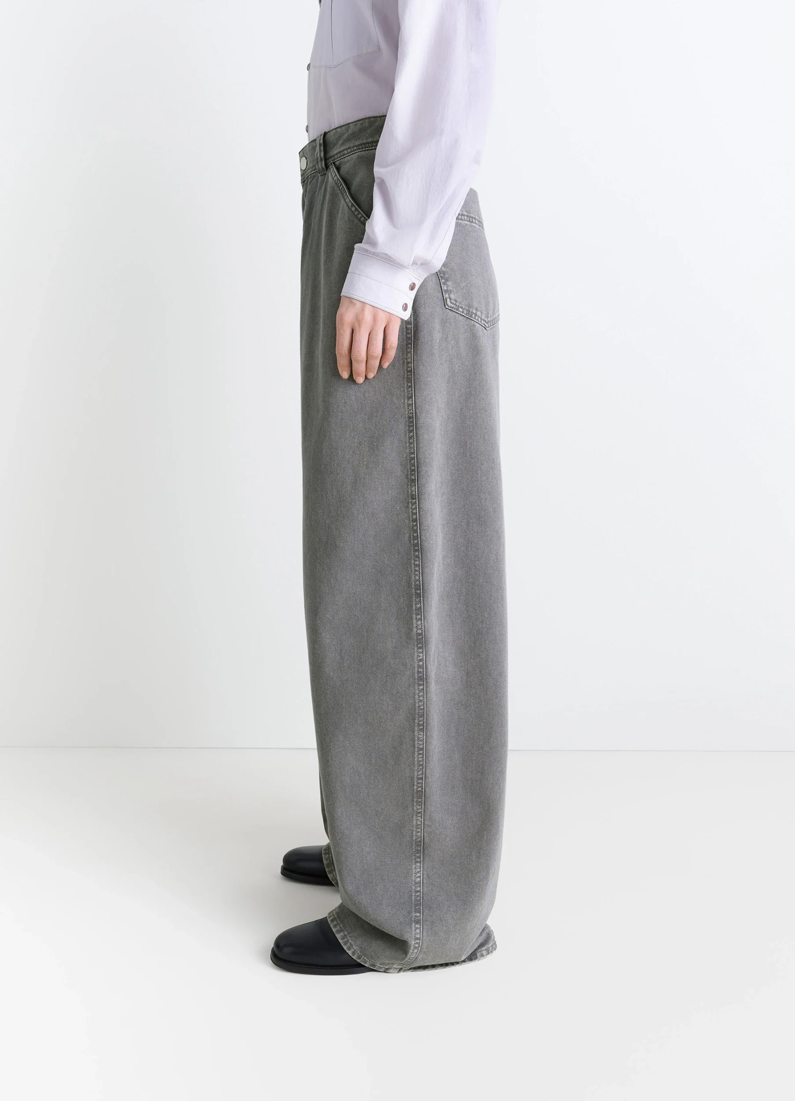 Lemaire wide leg pants in snow garment dyed denim, model shot, profile view full-length loose fit