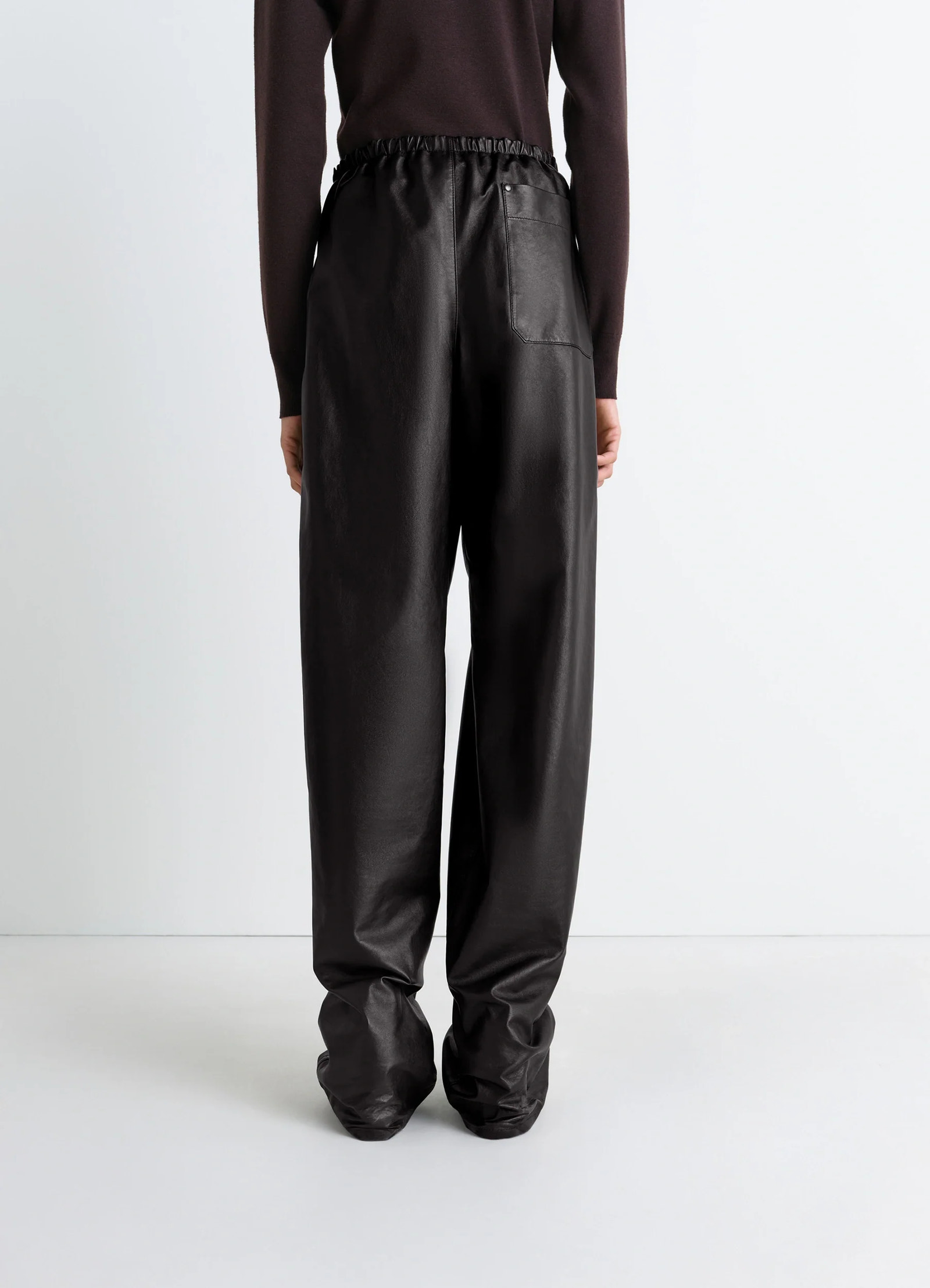 Lemaire soft leather pants in cow leather with natural shine, model shot, back view elastic waistband, loose fit