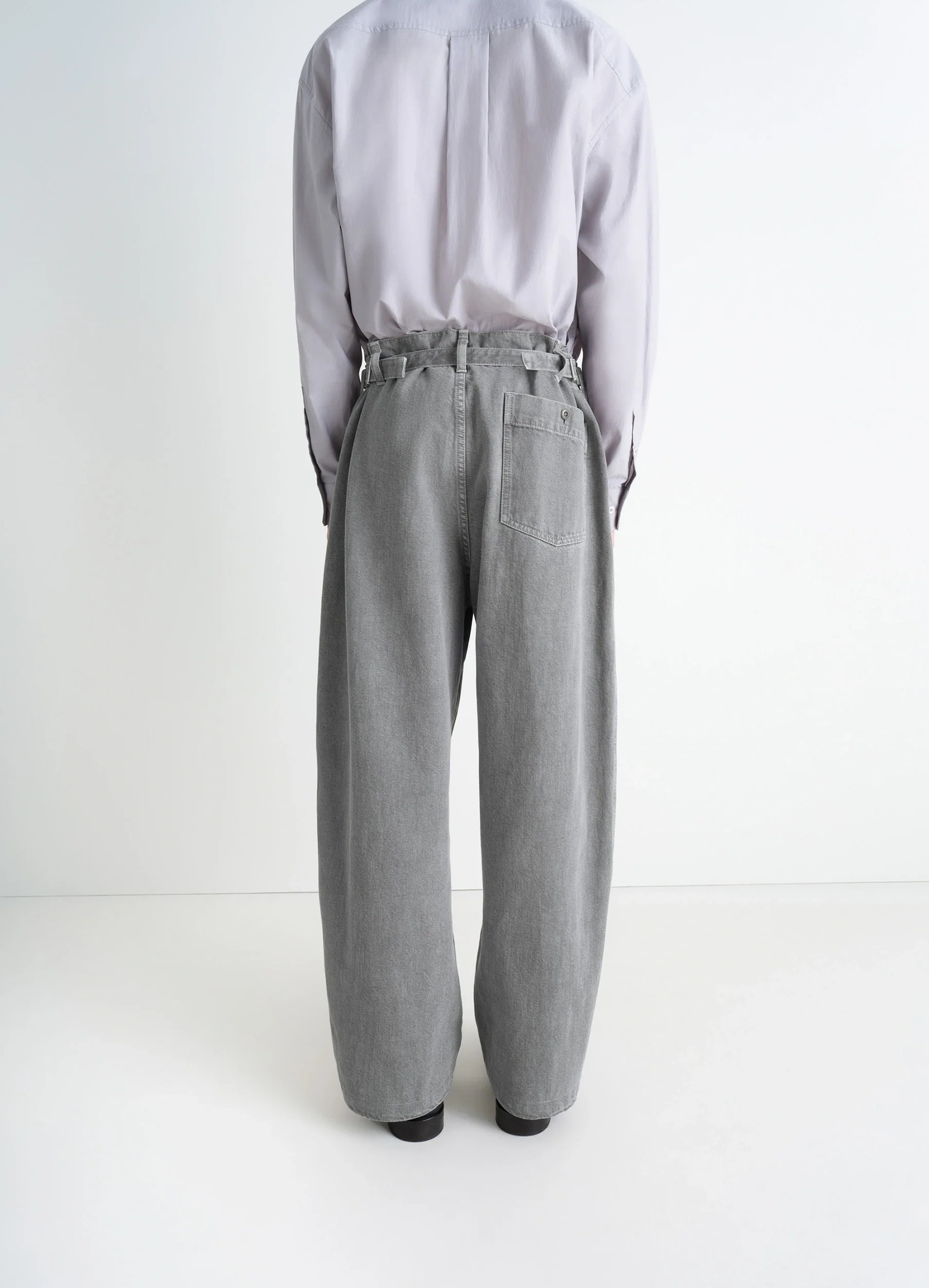 Lemaire maxi workwear pants in heather garment dyed snow heavy den, model shot, rear full body view high waist, buttoned back