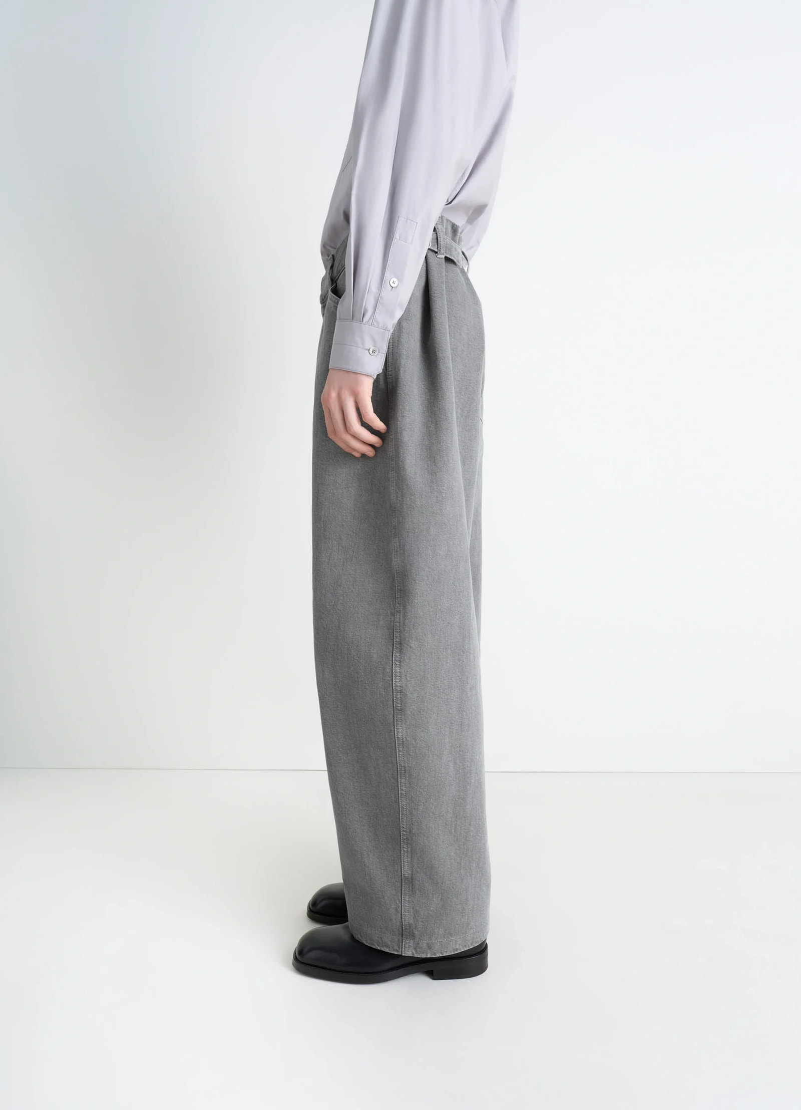 Lemaire maxi workwear pants in heather garment dyed snow heavy den, model shot, profile side view oversized with visible plea