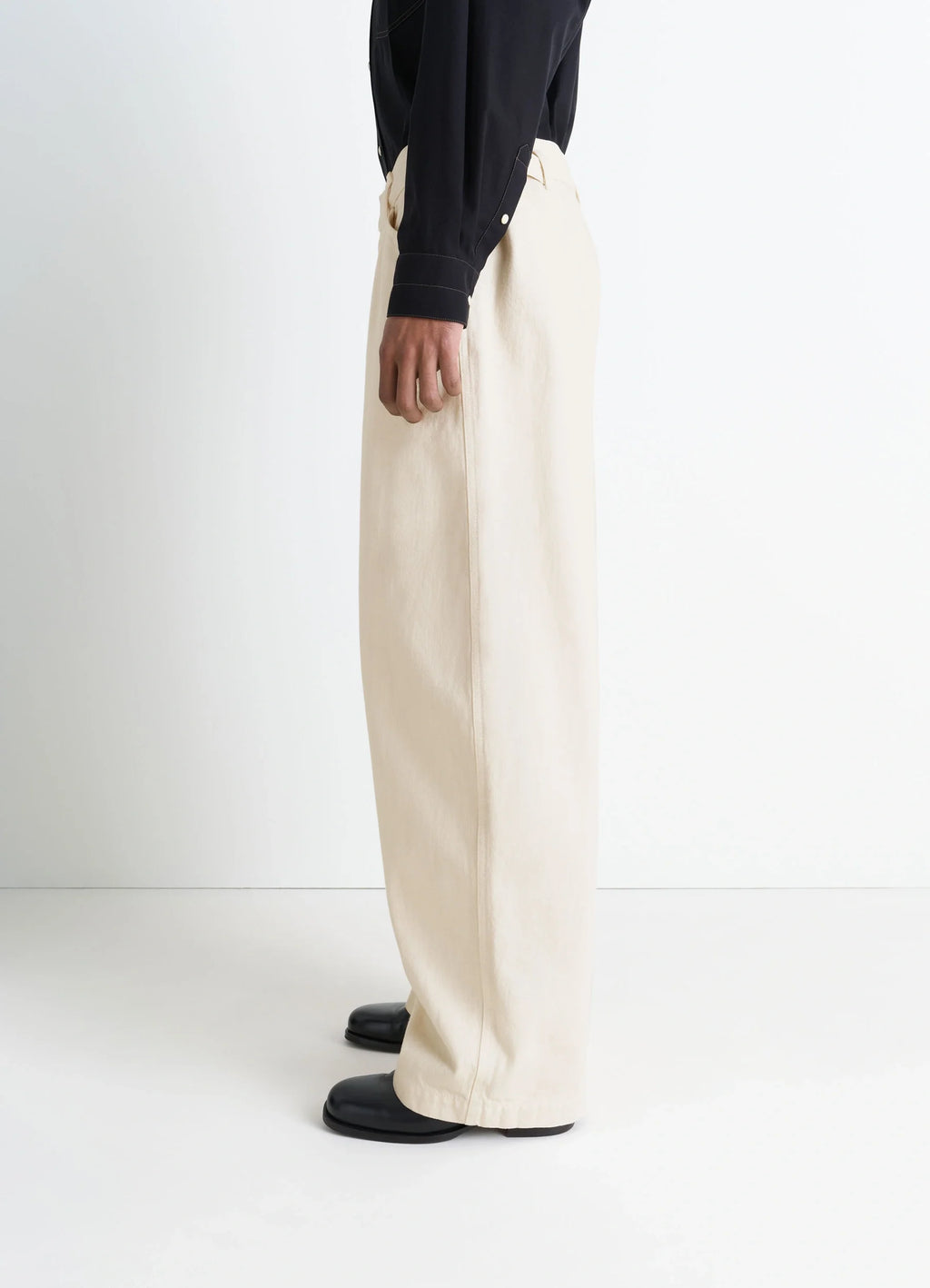 Lemaire Maxi Workwear Pants in Heather Garment Dyed Denim, model shot, side view wide leg, high waist