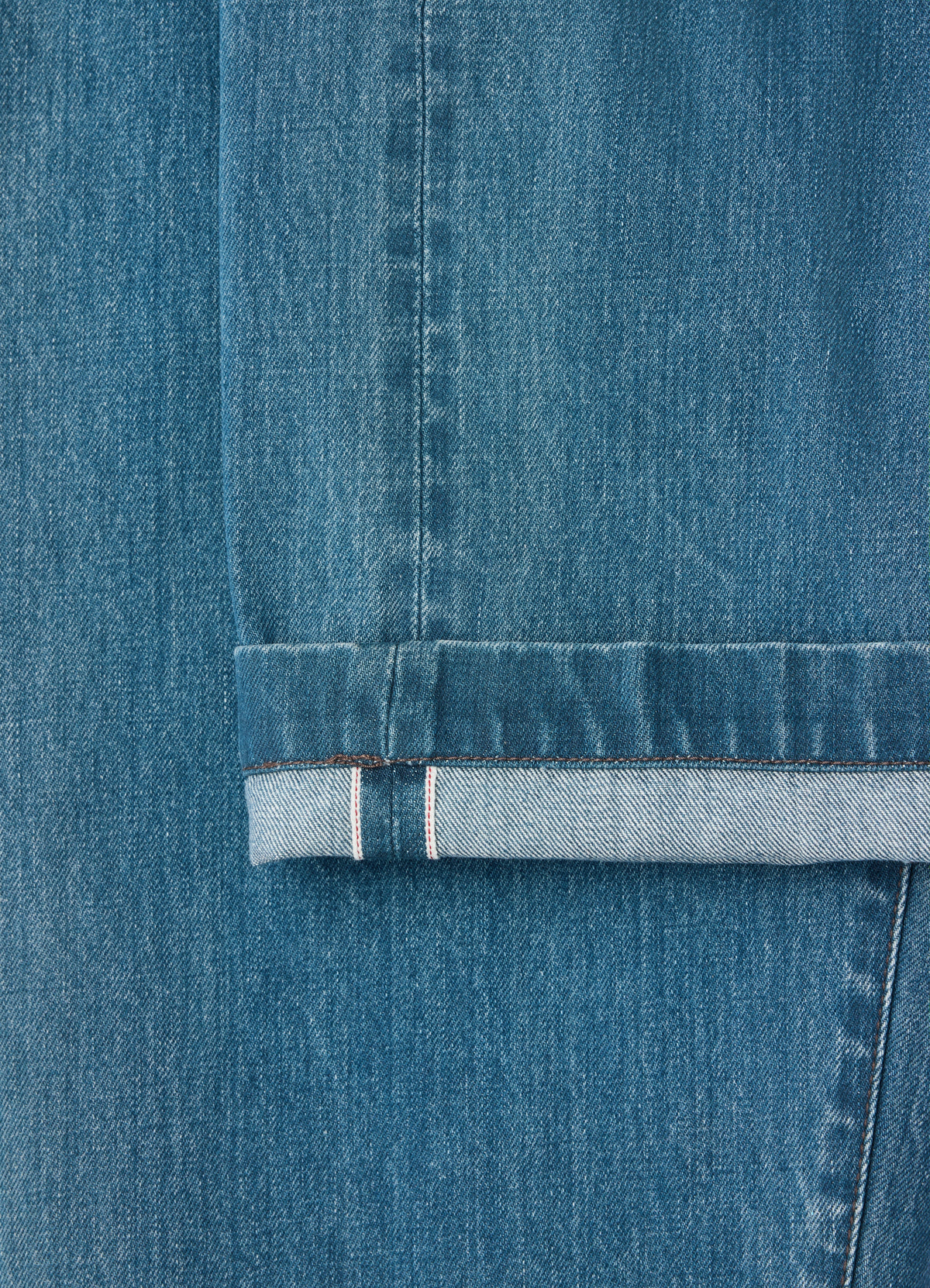 Oversized indigo selvedge denim workwear pants by lemaire close-up detail of cuff worn by a model