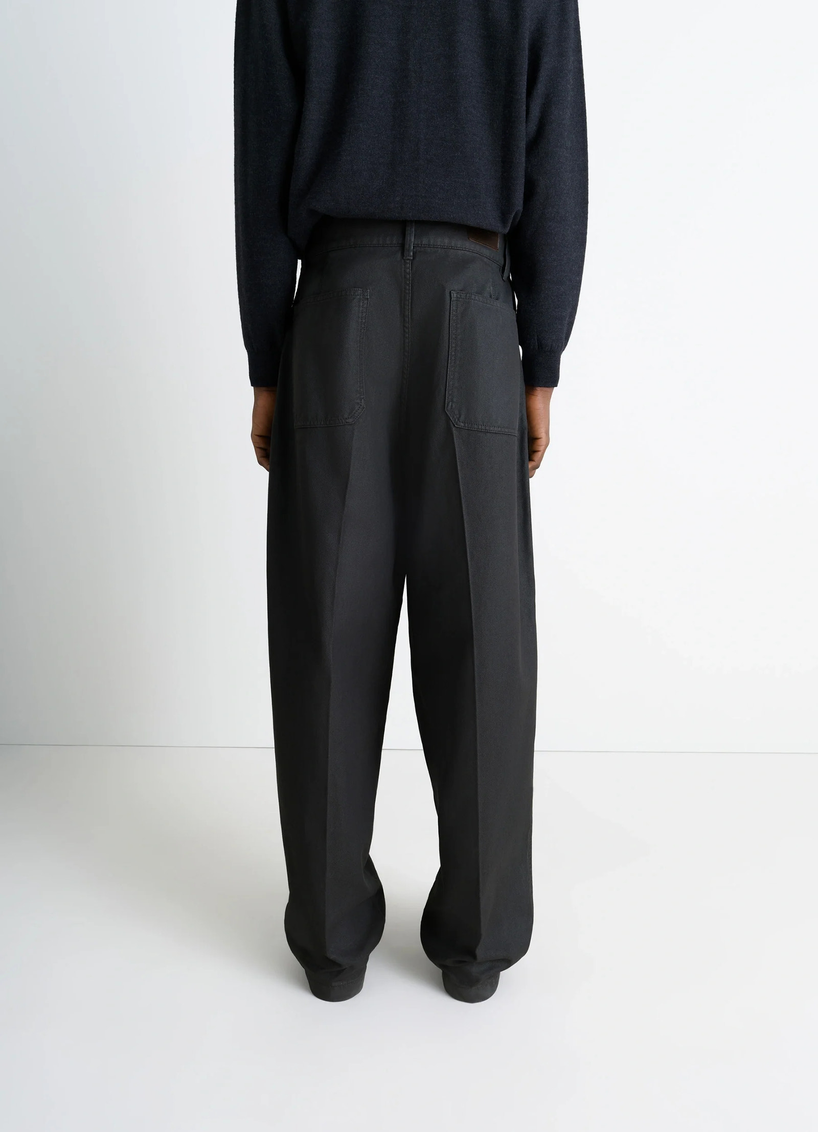 Lemaire maxi barrel workwear pants in glossy coated denim, model shot, back view straight leg