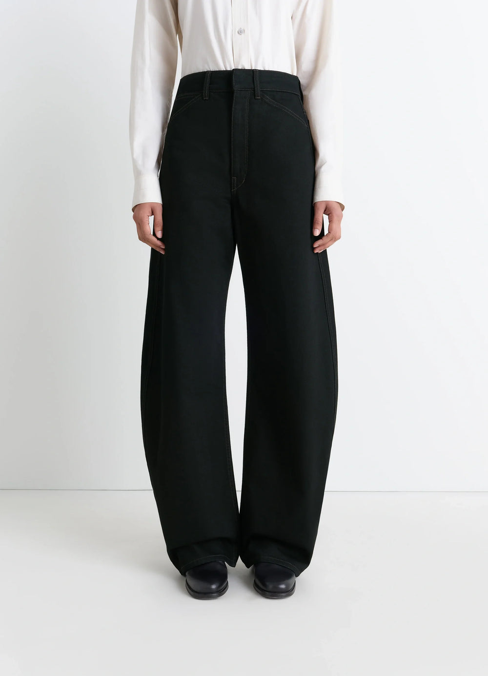 Lemaire High Waisted Curved Pants in Deep Black Thick Denim, model shot, front three-quarter view wide leg draped silhouette