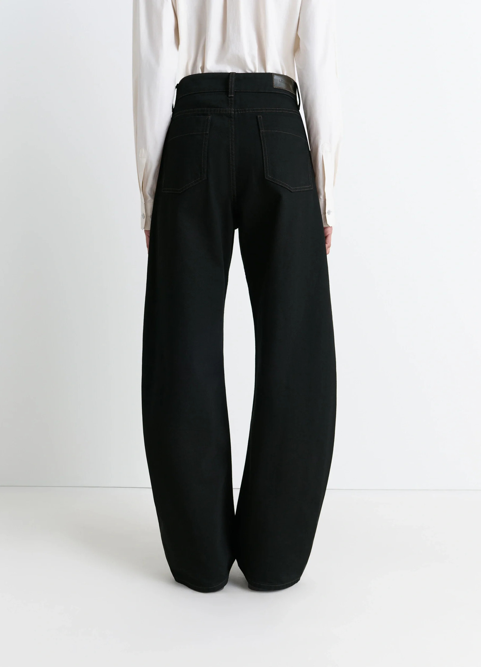 Lemaire high waisted curved pants in deep black thick denim, model shot, back view structured waist