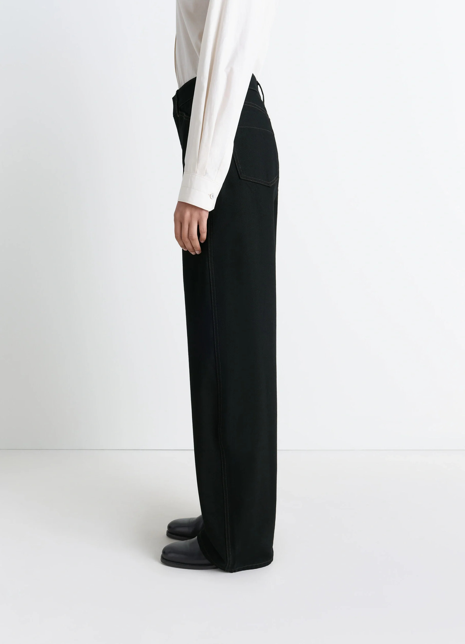 Lemaire high waisted curved pants in deep black thick denim, model shot, side view high waisted structured leg
