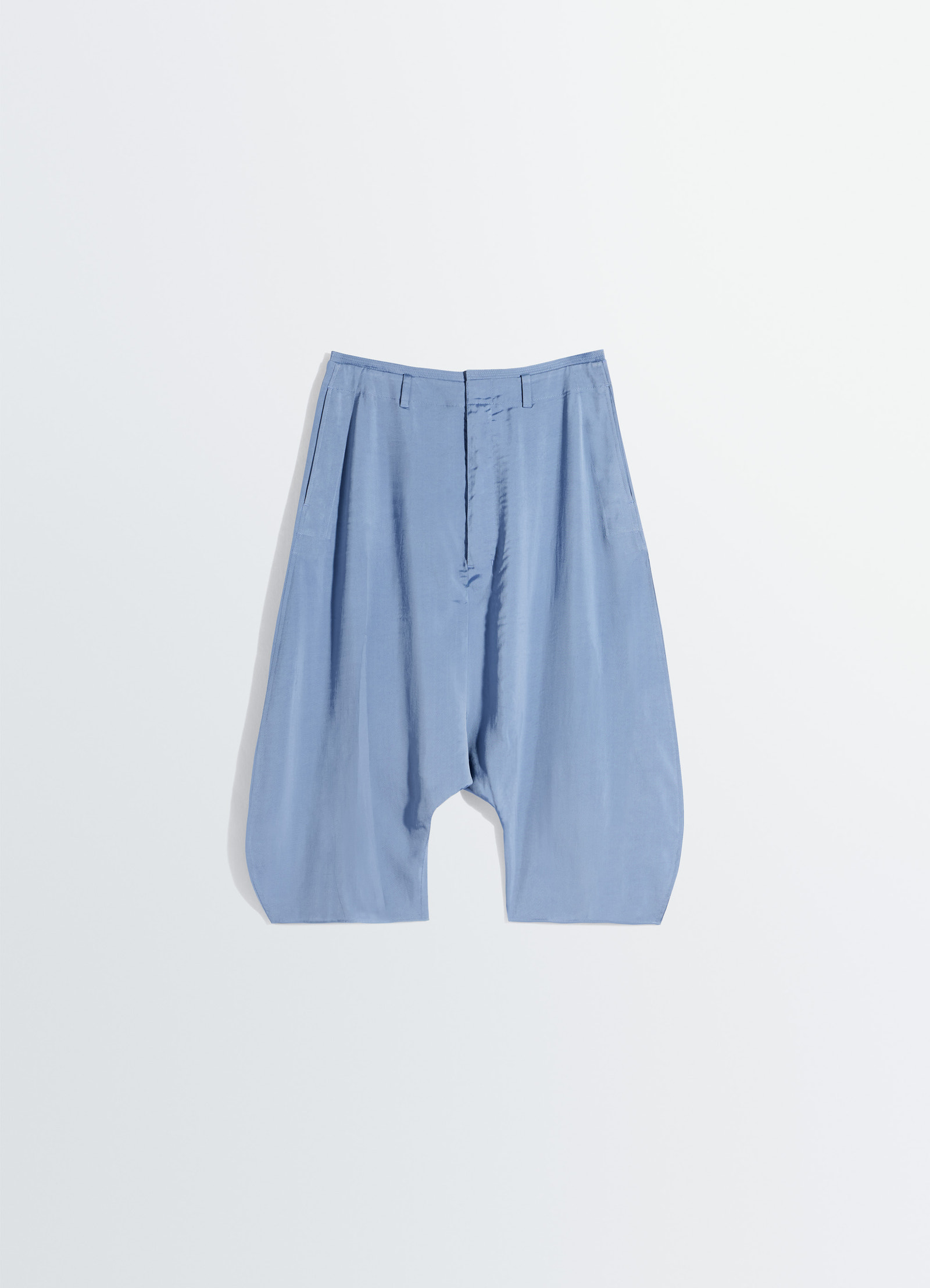 Creased dropped crotch bermudas in poly viscose twill, product shot, top-down view relaxed silhouette, pleated
