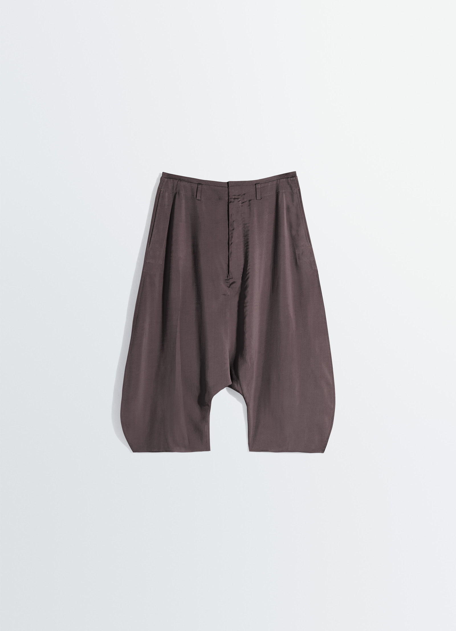 Creased dropped crotch bermudas in poly viscose twill, product shot, top down perspective draped fabric flow