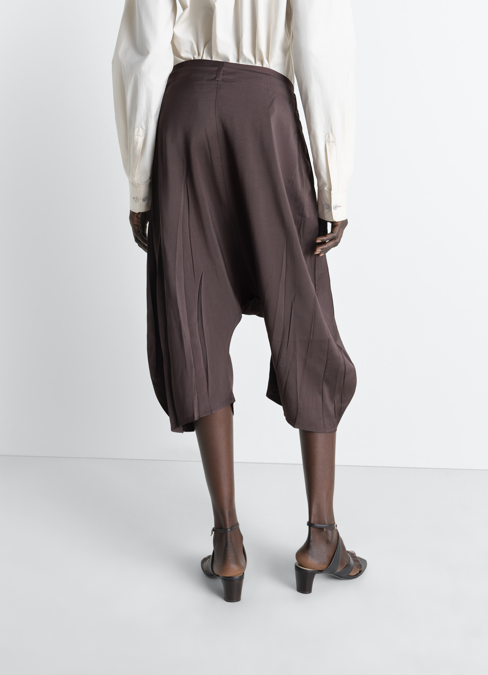 Creased dropped crotch bermudas in poly viscose twill, model shot, back view relaxed fit with flowing hem