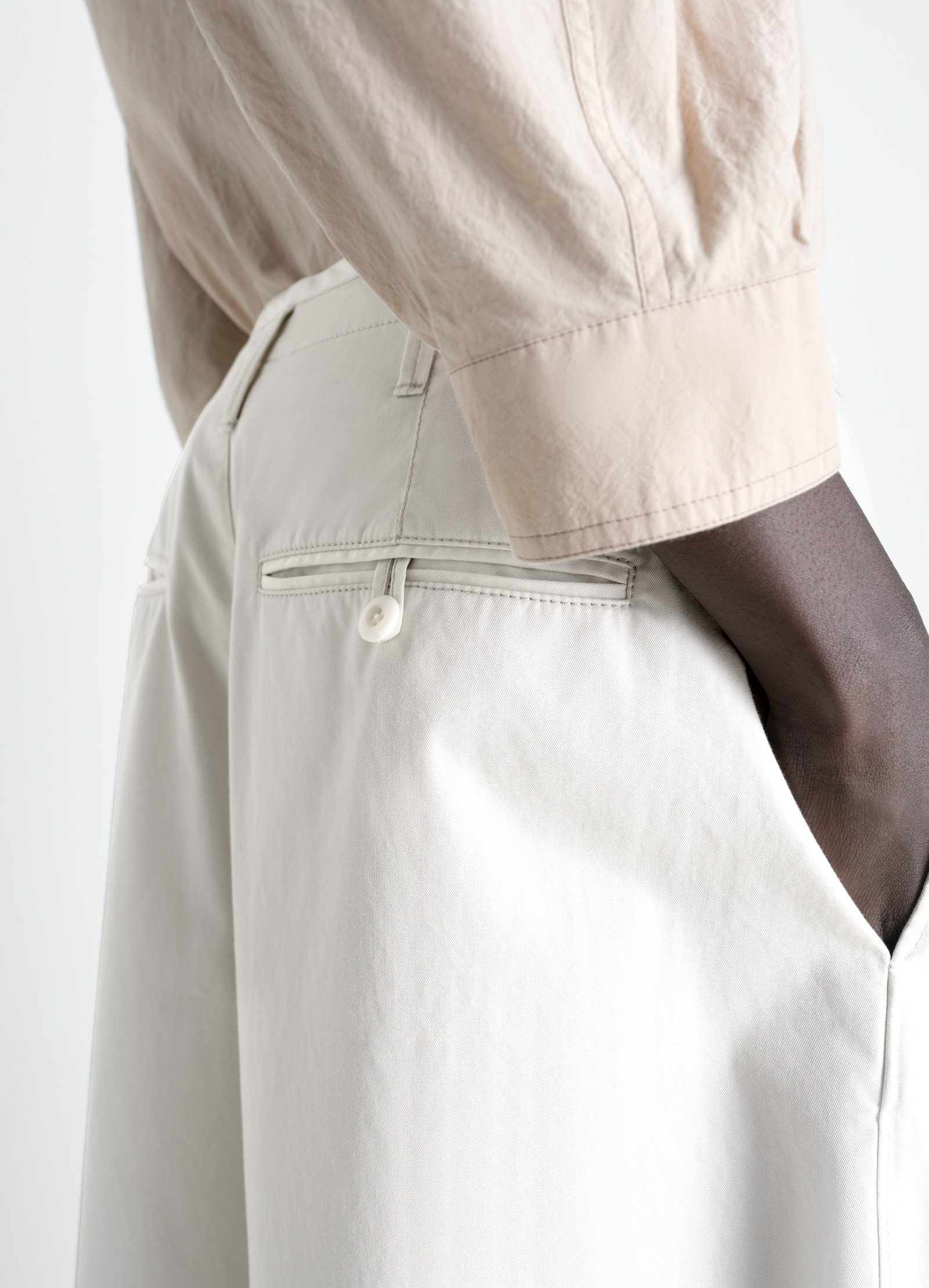 Lemaire large chino pants in cotton twill, model shot, rear close-up buttoned back pocket