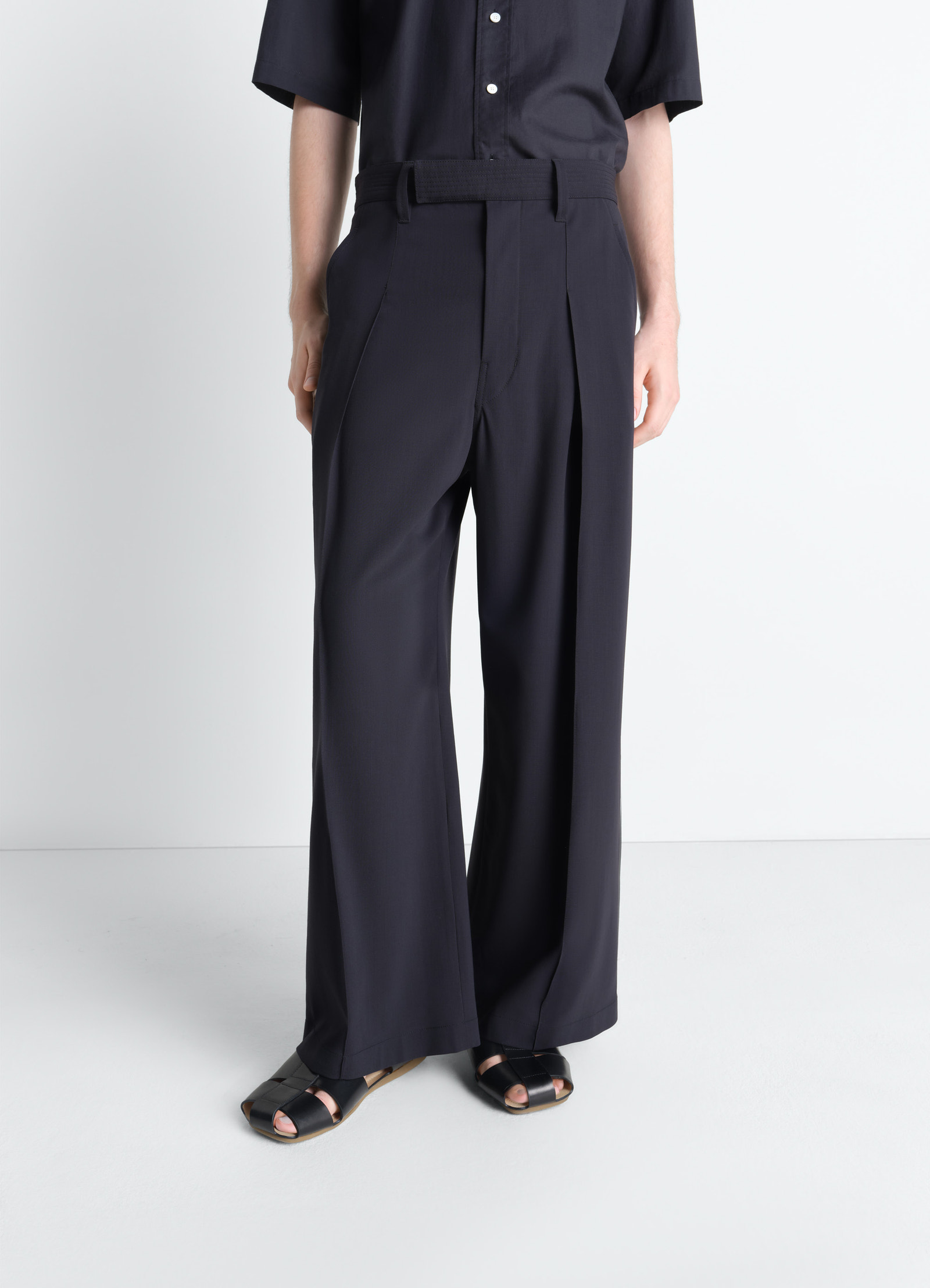 Single pleat pants in wool crêpe, model shot, angled front view pleated with belt