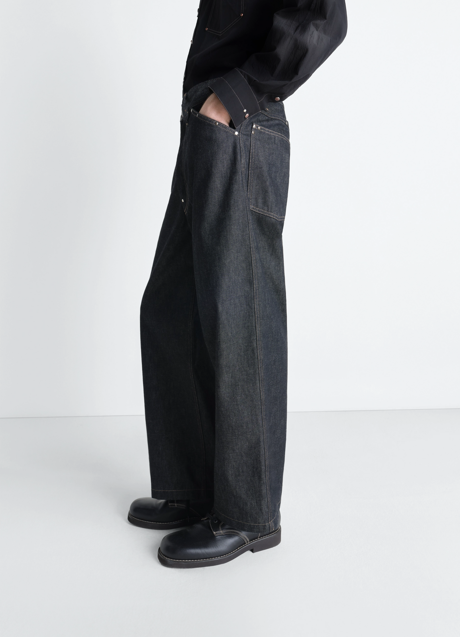 Lemaire wide pant with studs in slate denim, model shot, three-quarter view loose fit back pockets