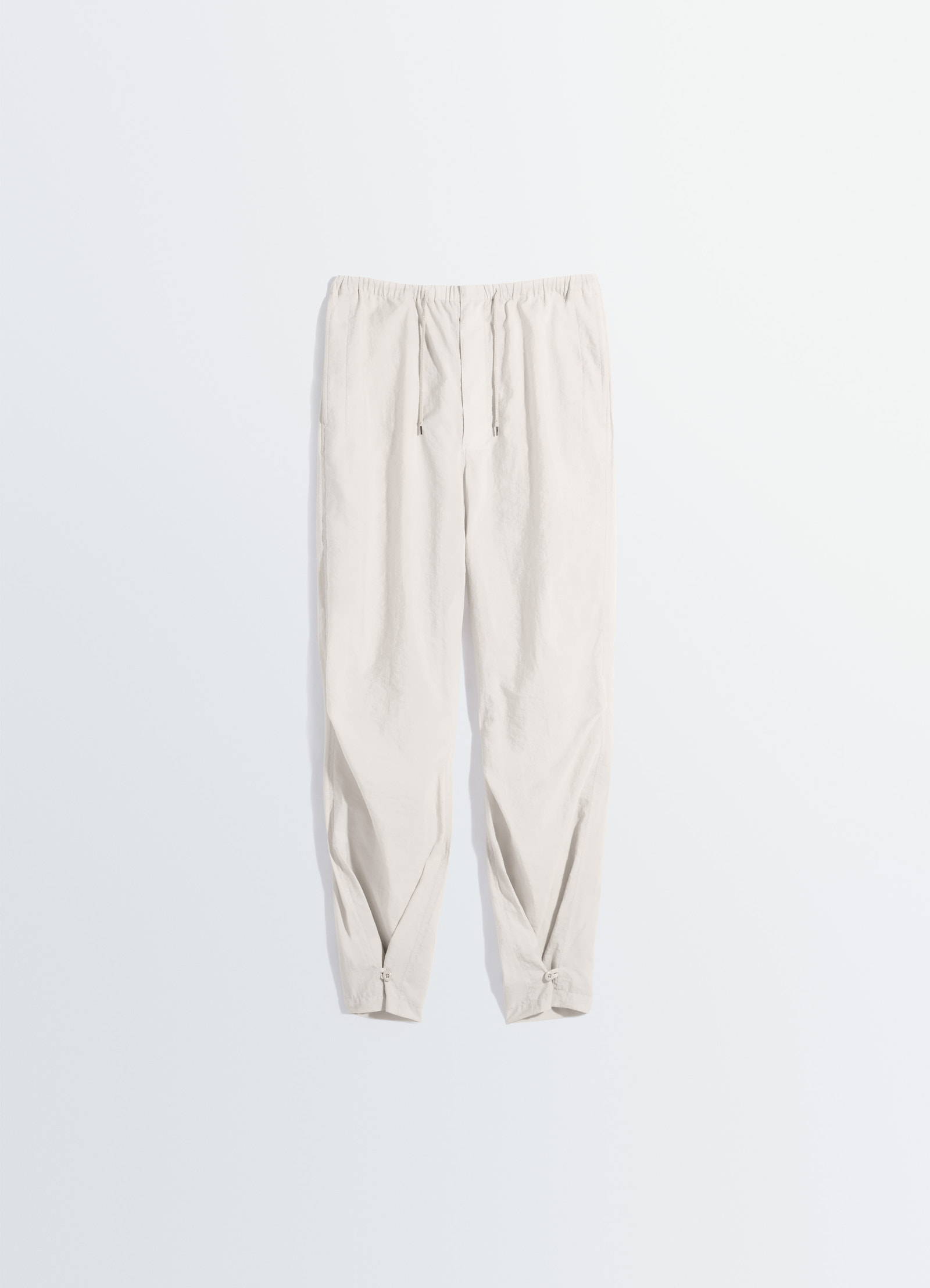 Lemaire parachute pants in washed technical cotton, product shot, top down view gathered ankle detail