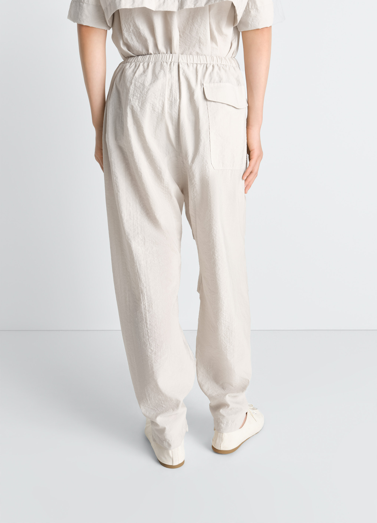 Lemaire parachute pants in washed technical cotton, model shot, rear view elastic waistband loose fit