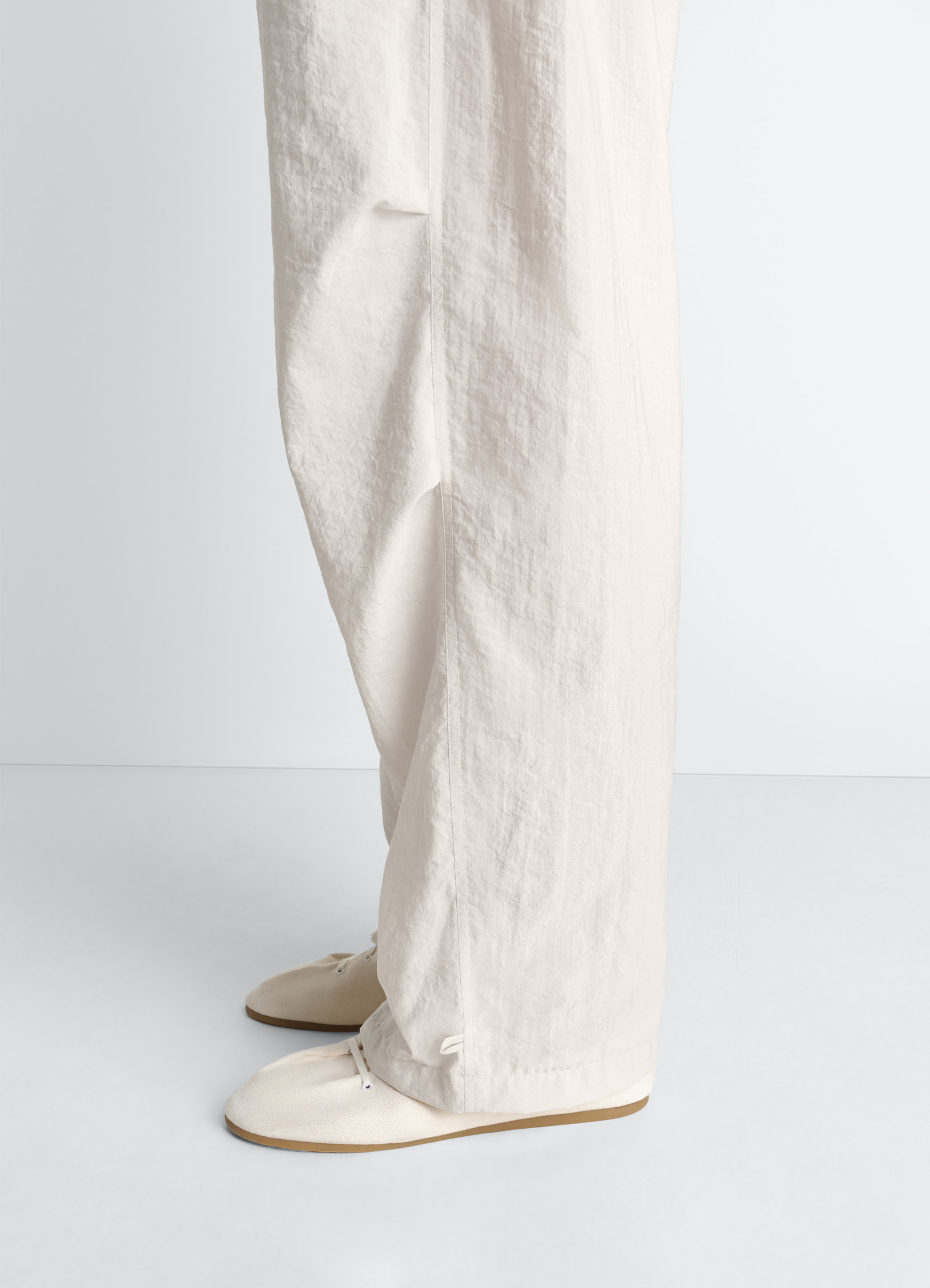 Lemaire parachute pants in washed technical cotton, model shot, side view straight leg profile