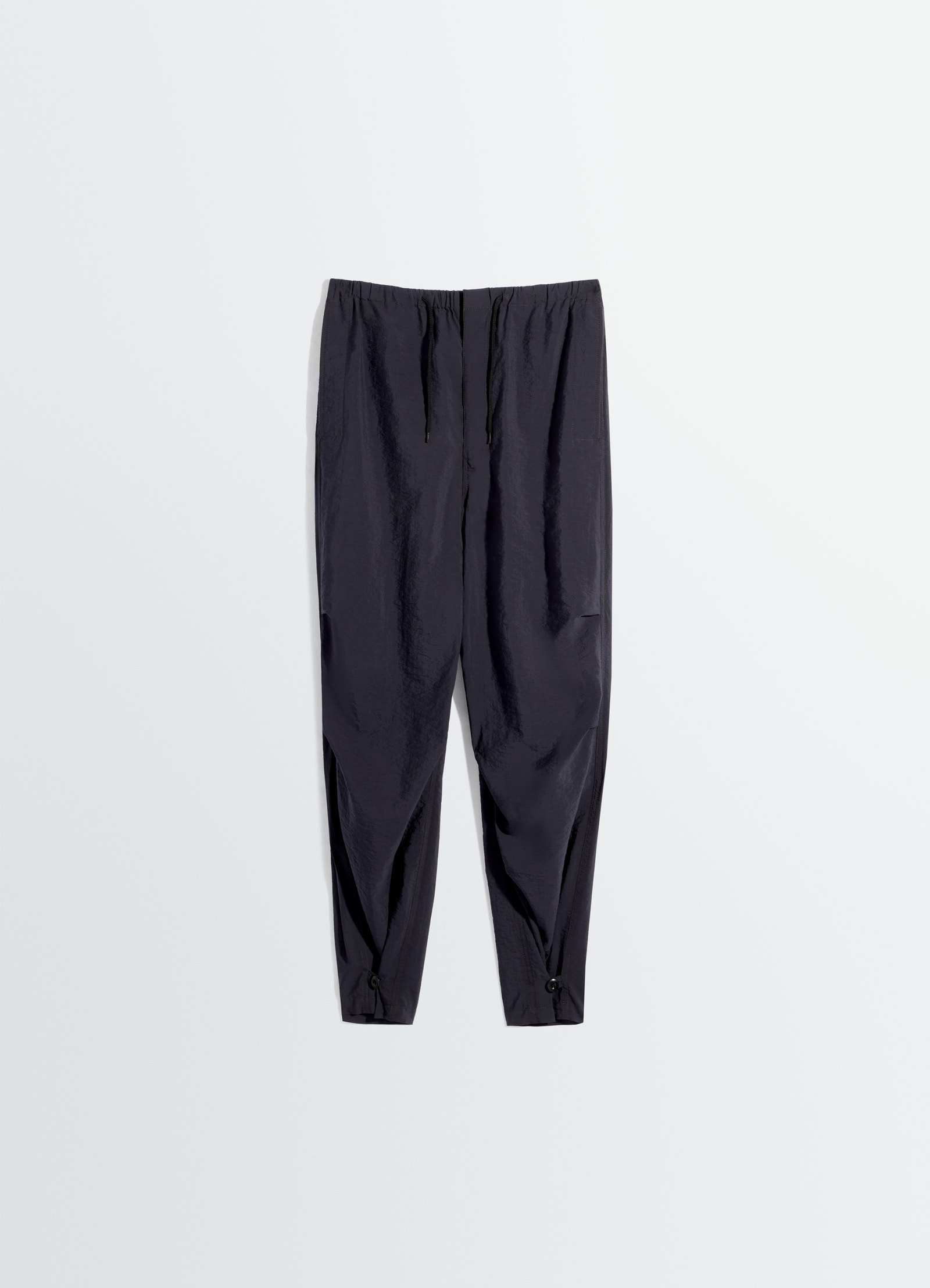 Parachute pants in washed technical cotton, product shot, overhead view elastic waist drawstring