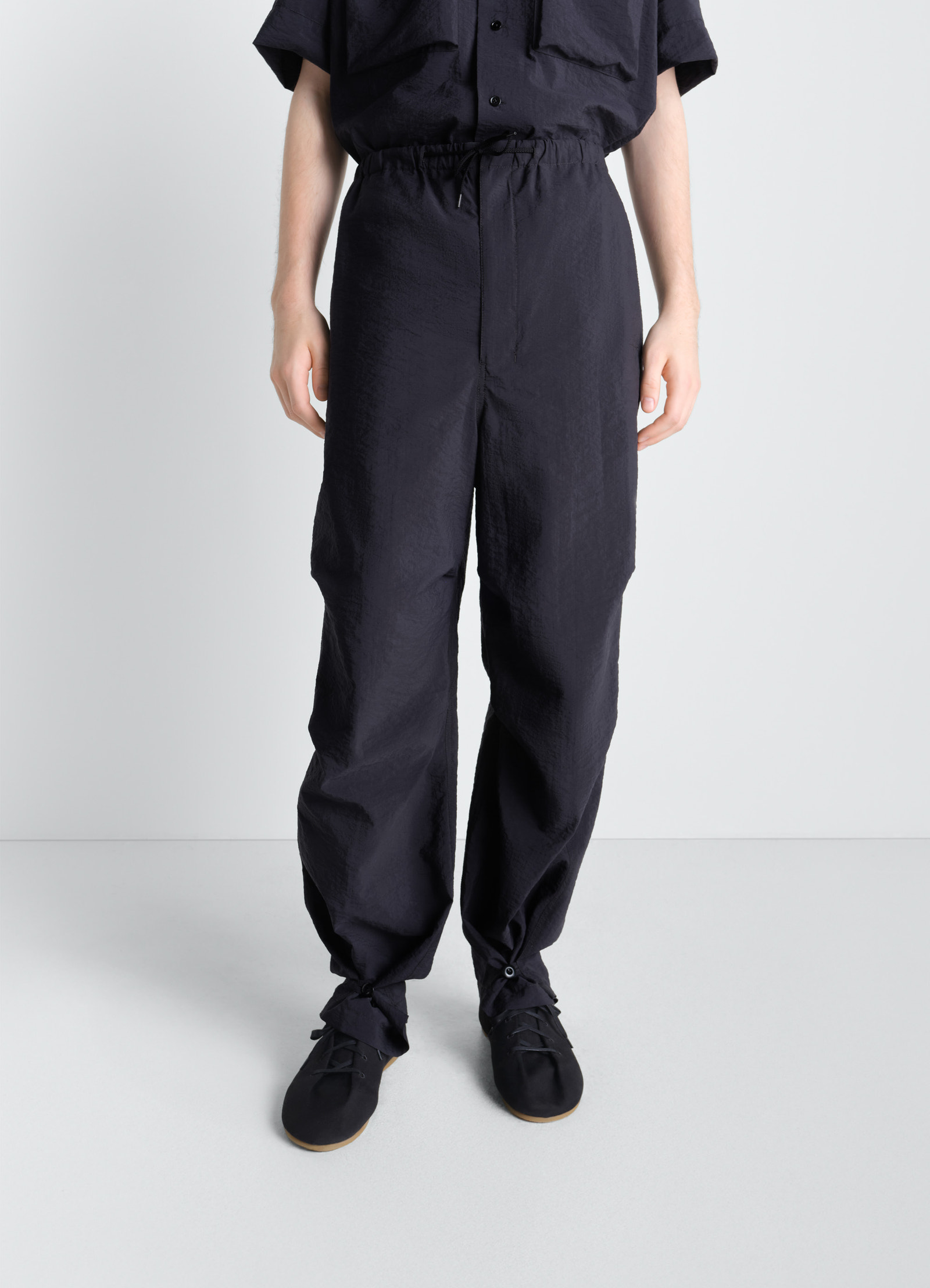 Parachute pants in washed technical cotton, model shot, back view elastic waist tie detail
