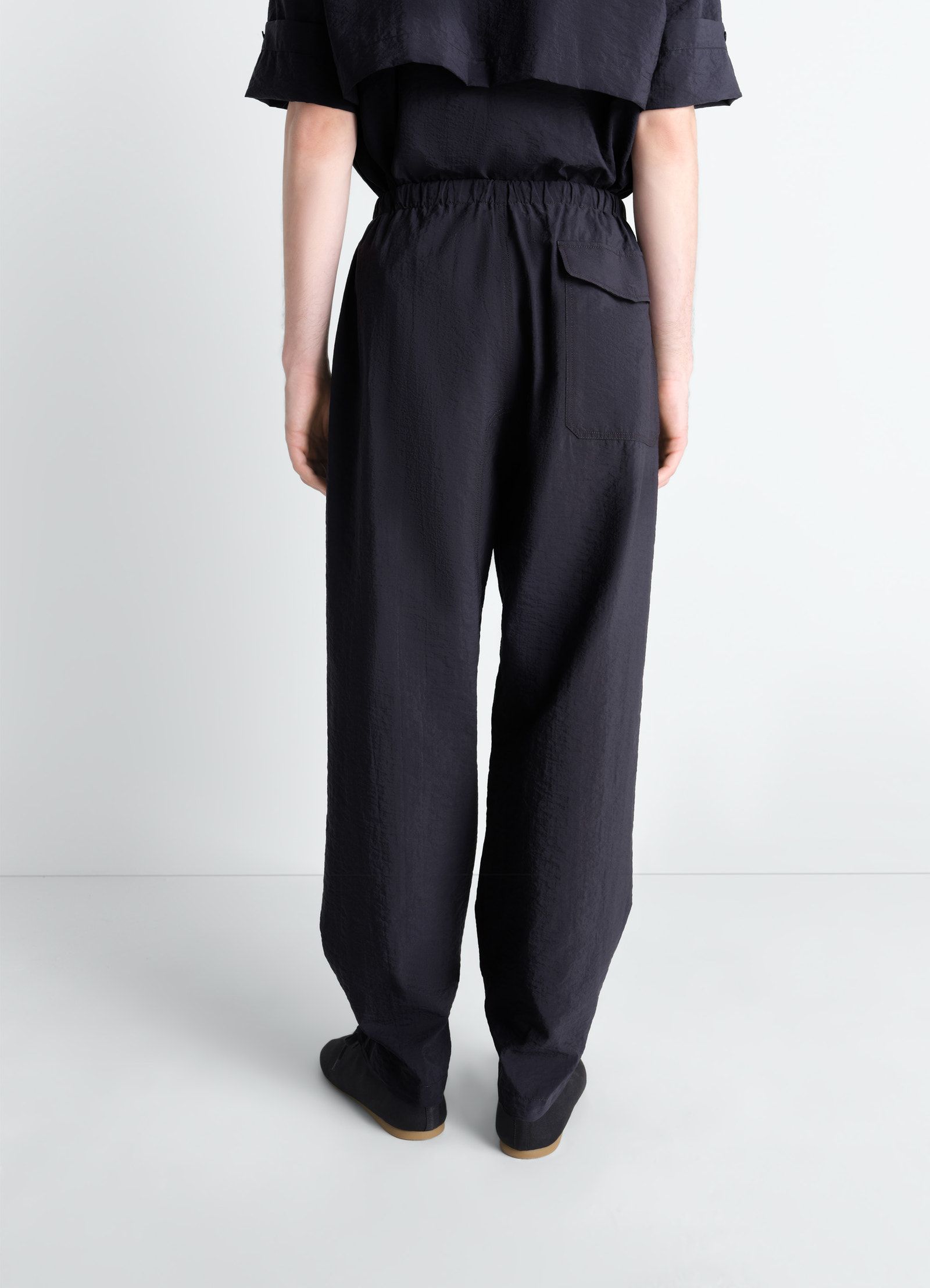 Parachute pants in washed technical cotton, model shot, three-quarter back view elastic waist back pocket