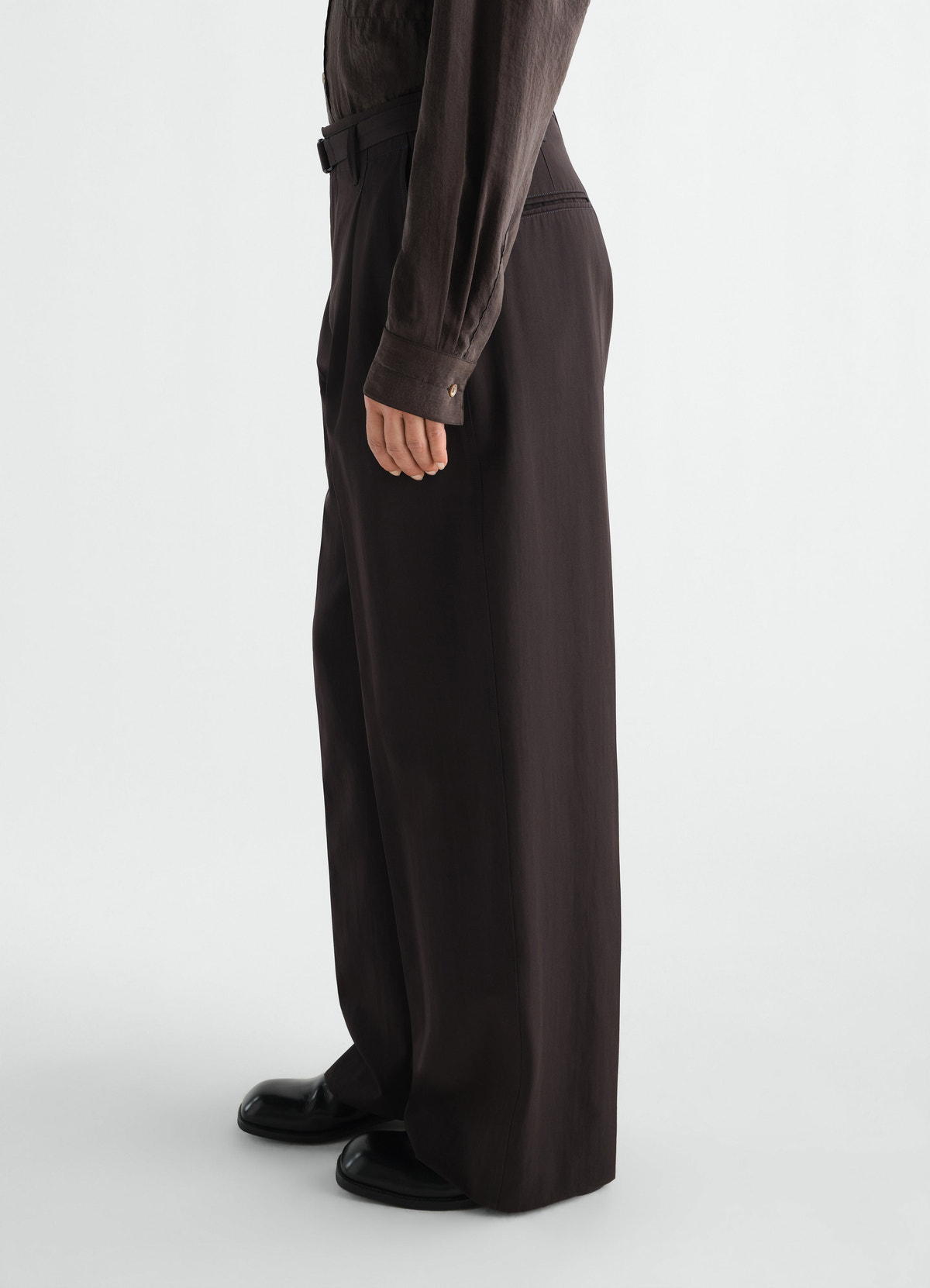 Wide pleated wool gabardine pants in dark brown by lemaire worn by model side view