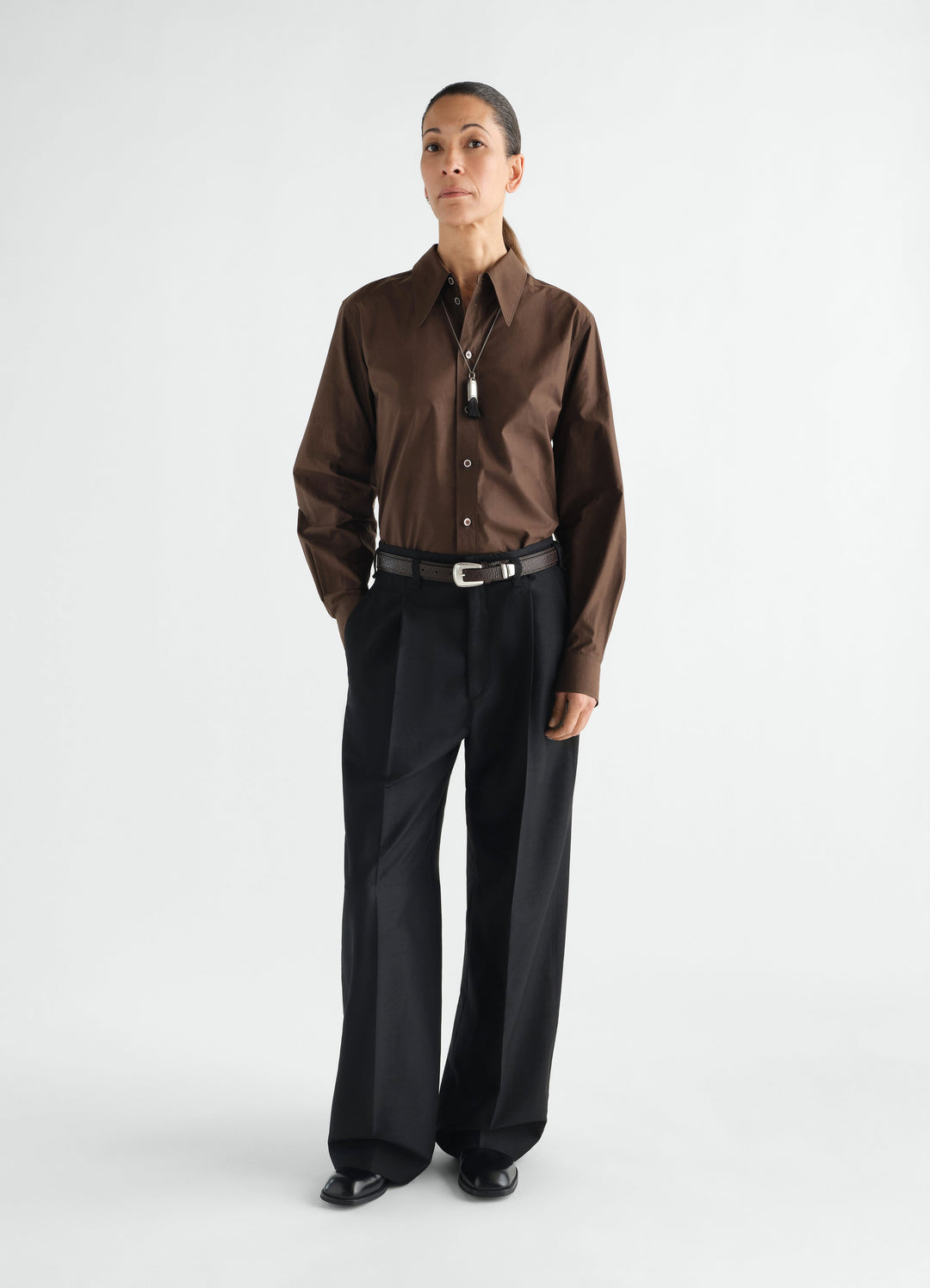 Wide black wool mohair pleated pants LEMAIRE worn by a model front view with belt and brown shirt