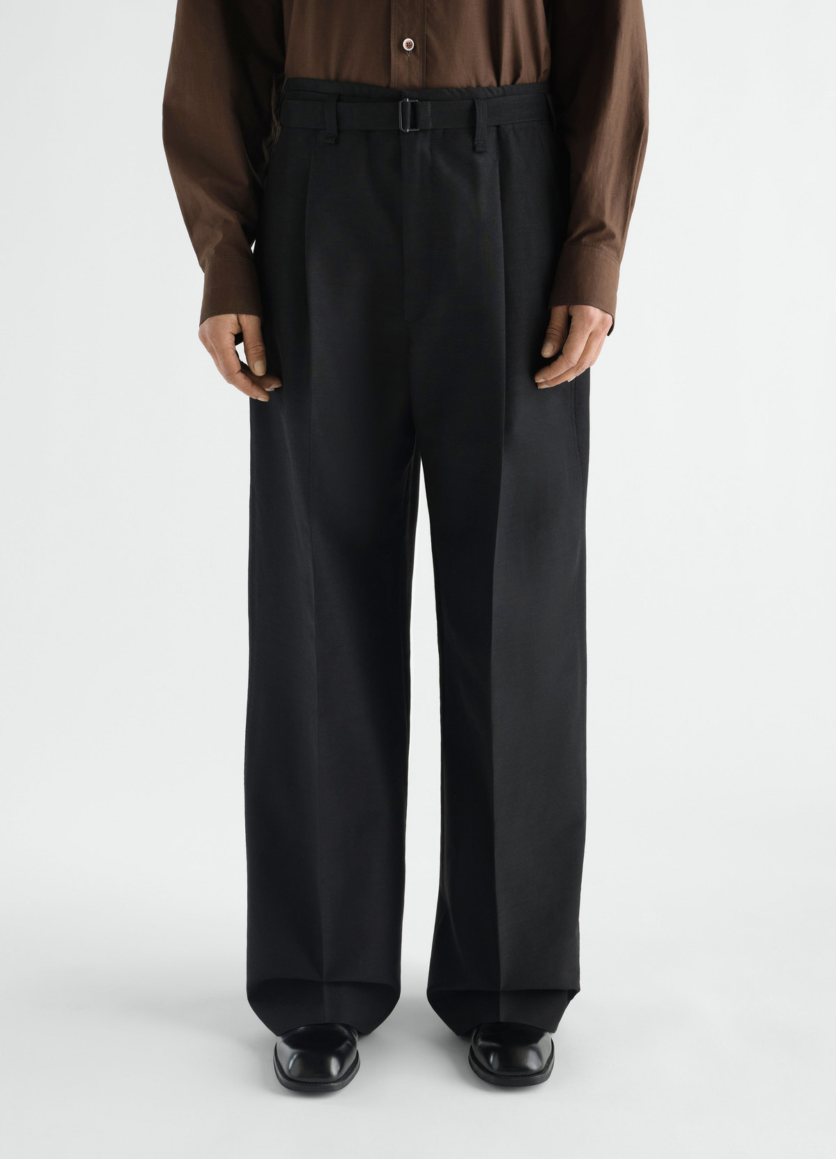 Wide black wool mohair pleated pants with belt detail by lemaire worn by model front view