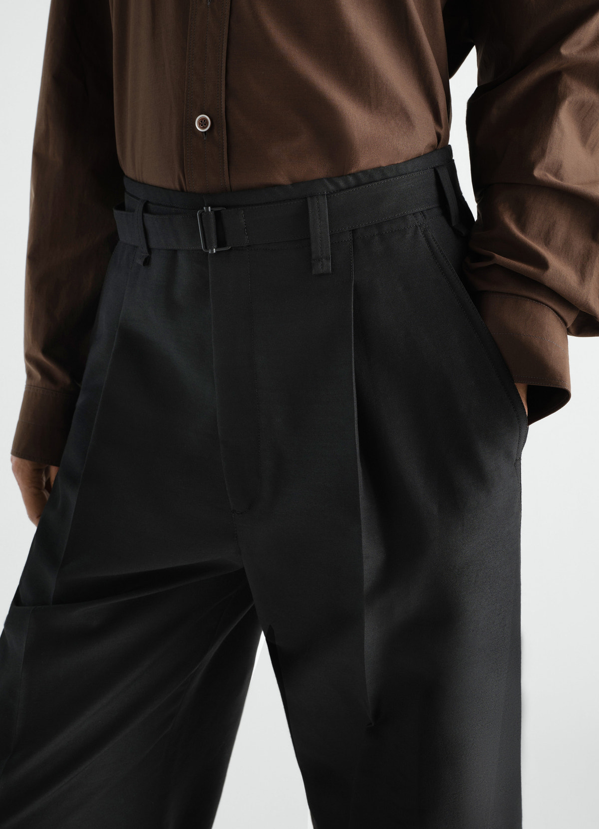 Wide pleated black wool mohair pants with belt worn by model front view lemaire