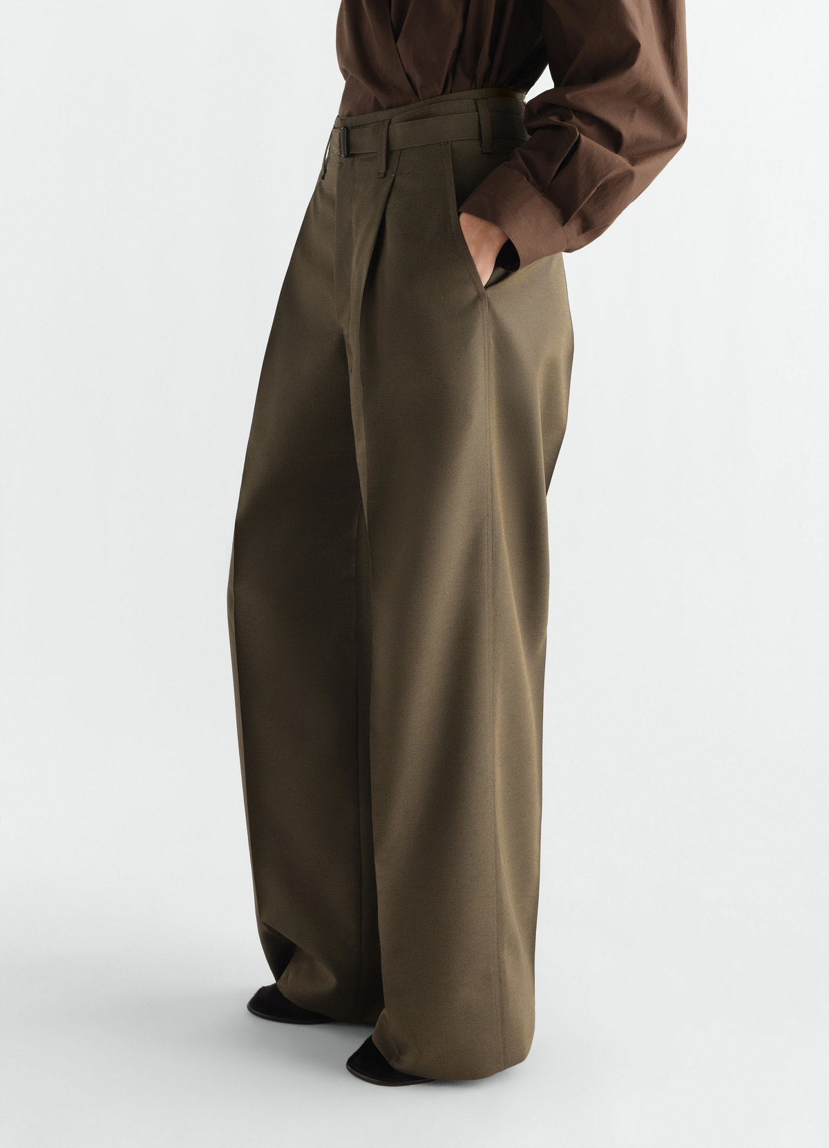 Wide pleated wool mohair pants in olive green worn by model with brown top lemaire side view