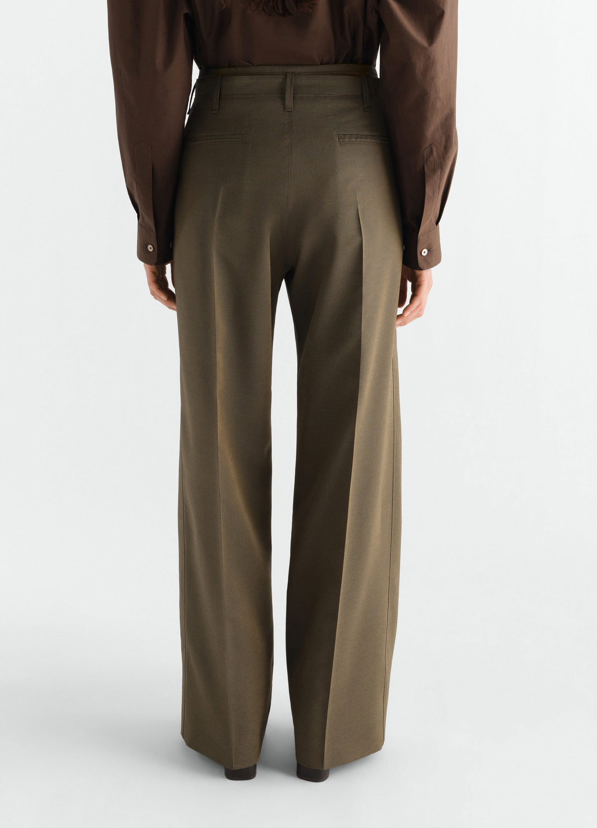 Wide pleated wool and mohair trousers in olive green by lemaire, back view worn by model with brown shirt