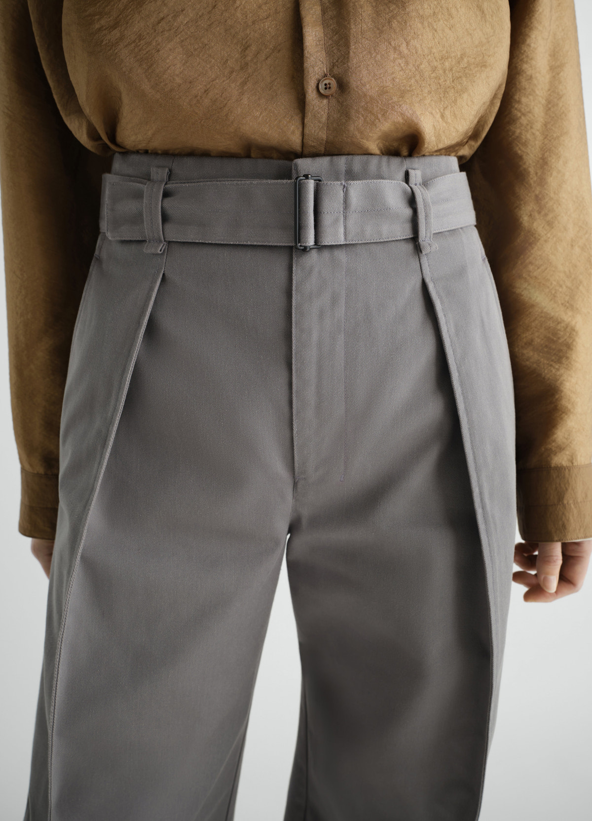Hose mit abgerundetem schnitt aus poly-baumwoll-twill, in grau, von einem model getragen, nahaufnahme von vorn, gürtel sichtbar