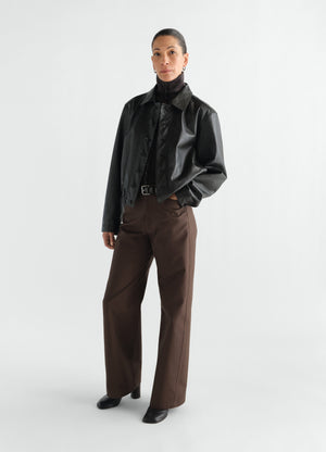 Straight brown heavy cotton twill pants lemaire worn by model with black leather jacket front view