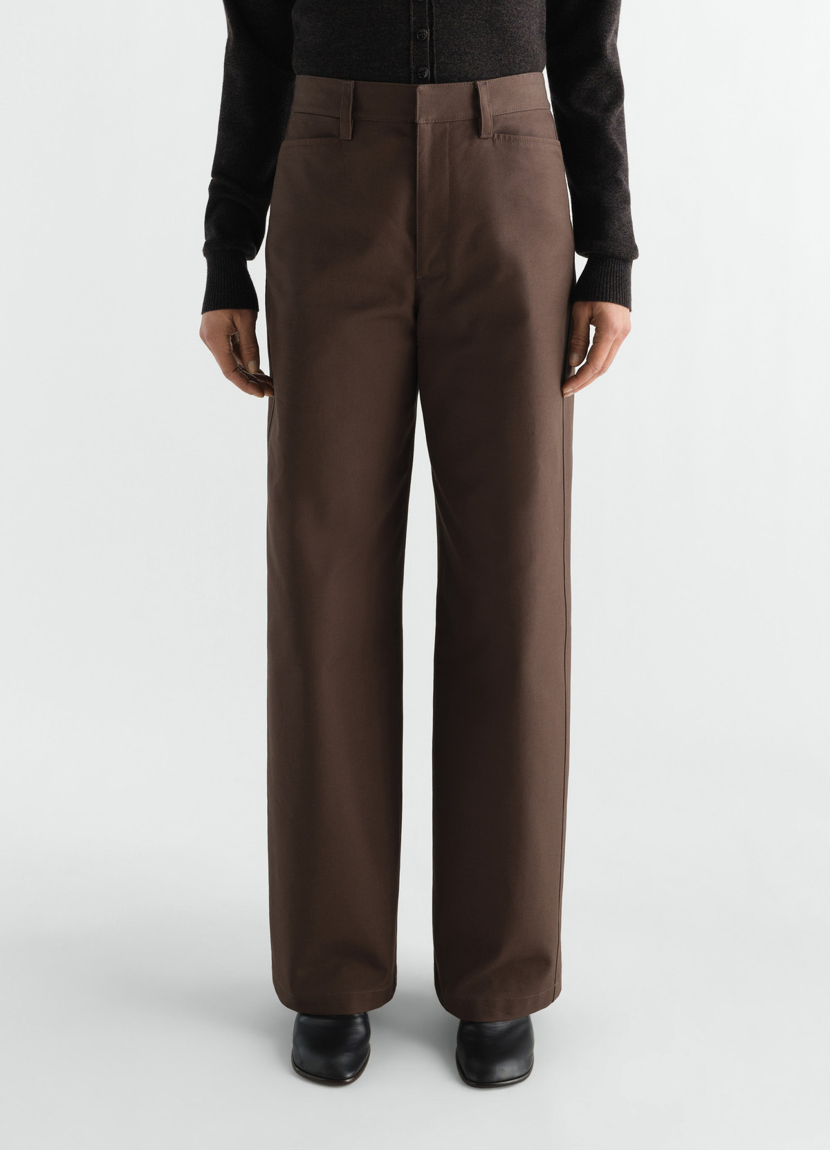 Straight heavy cotton twill brown pants by lemaire worn by model front view with black boots and top