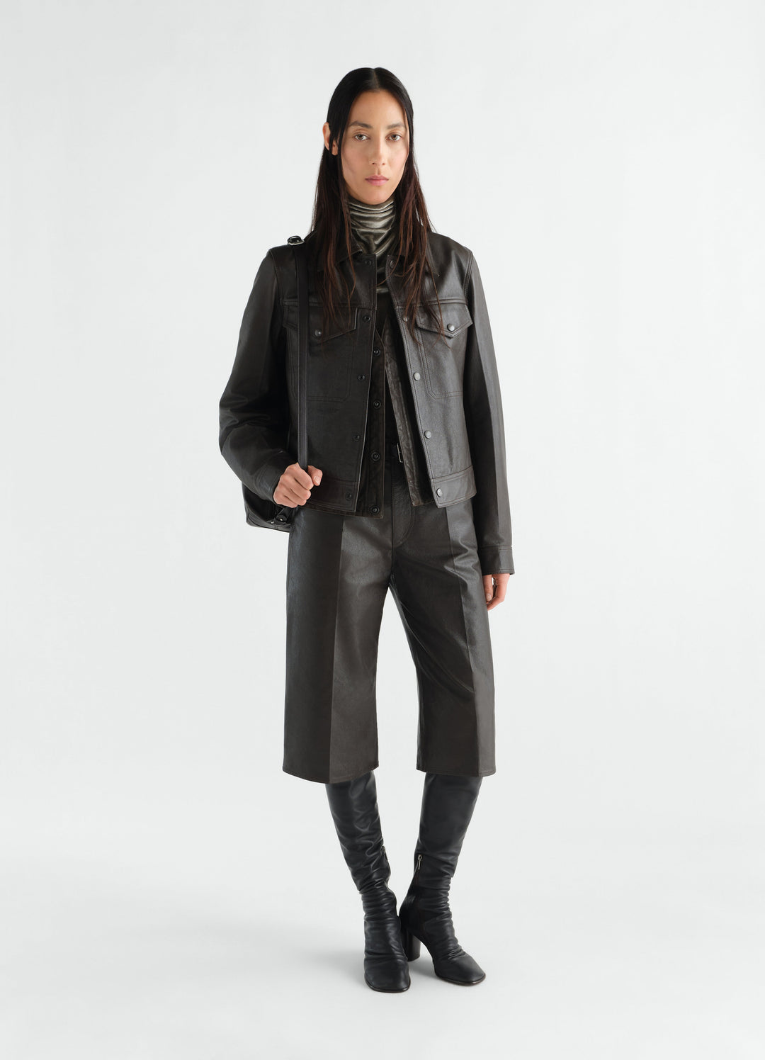 Bermuda en cuir glossy, coloris noir, porté par un mannequin