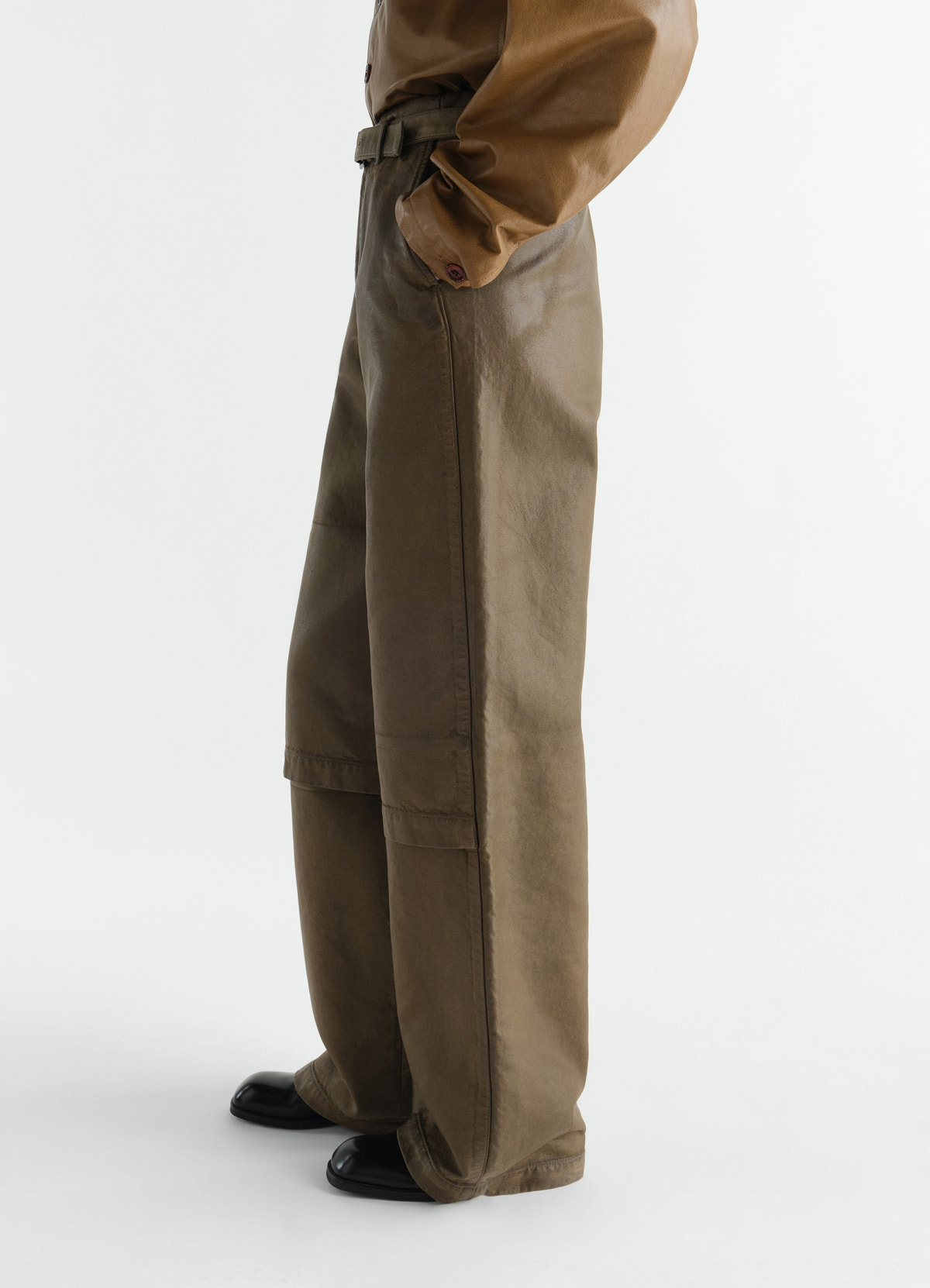 Work pants lemaire in coated brown cotton broken twill worn by model side view with belt and black shoes