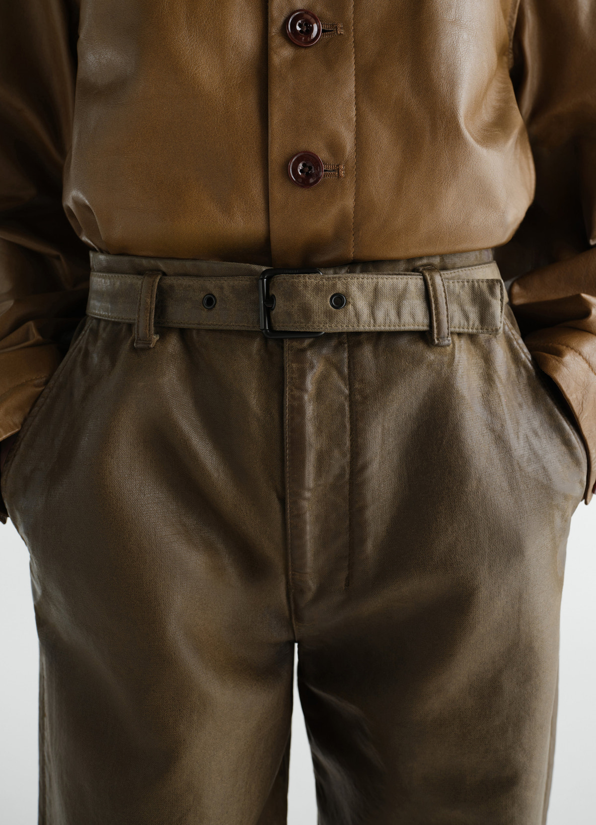 Work pants lemaire in brown coated broken twill fabric worn by model front close-up with belt
