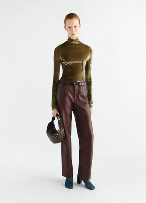 Straight brown glossy leather pants worn by model with belt and lemaire brown bag front view