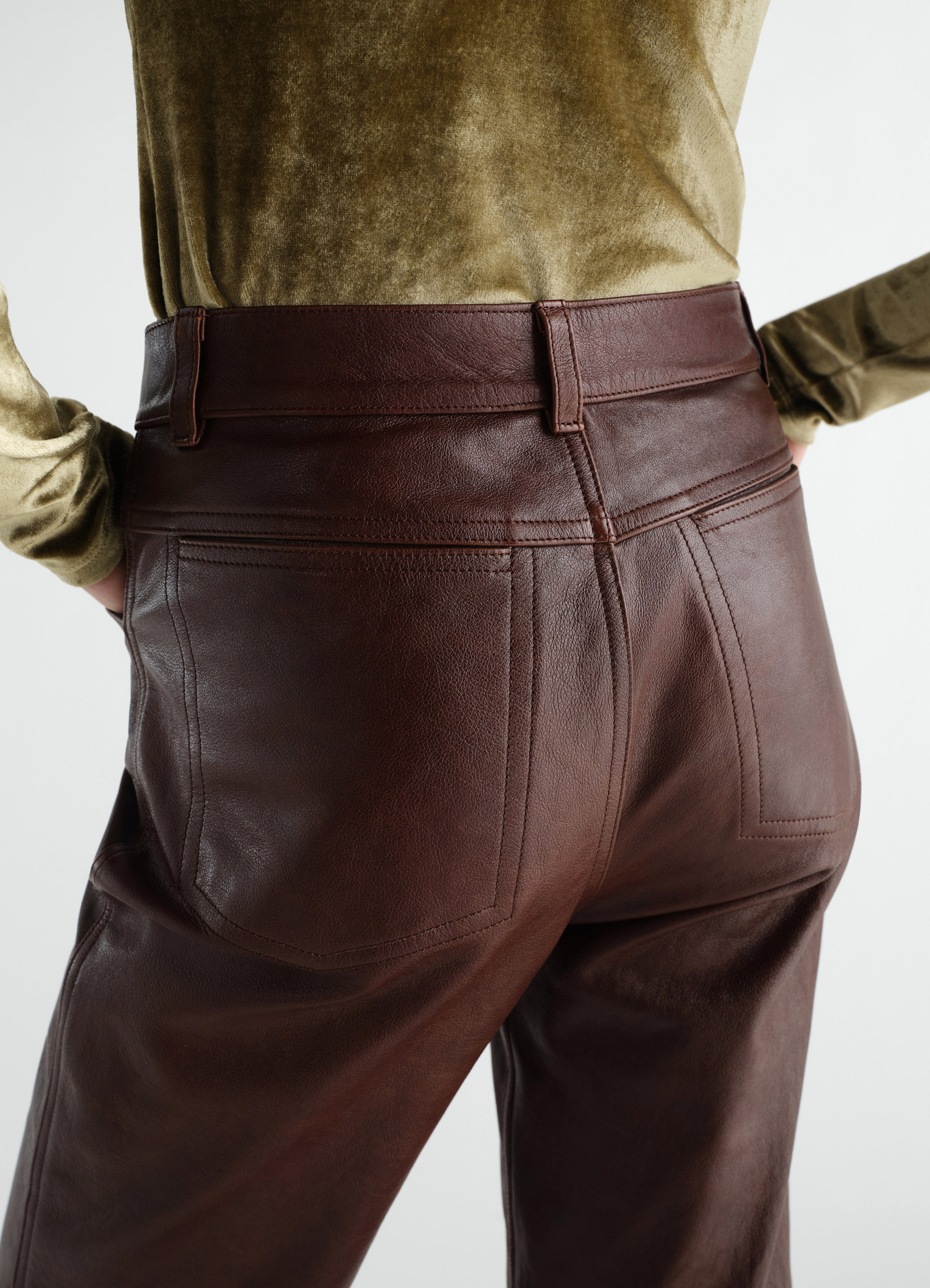 Straight glossy brown leather pants lemaire worn by a model back view with stitched pockets