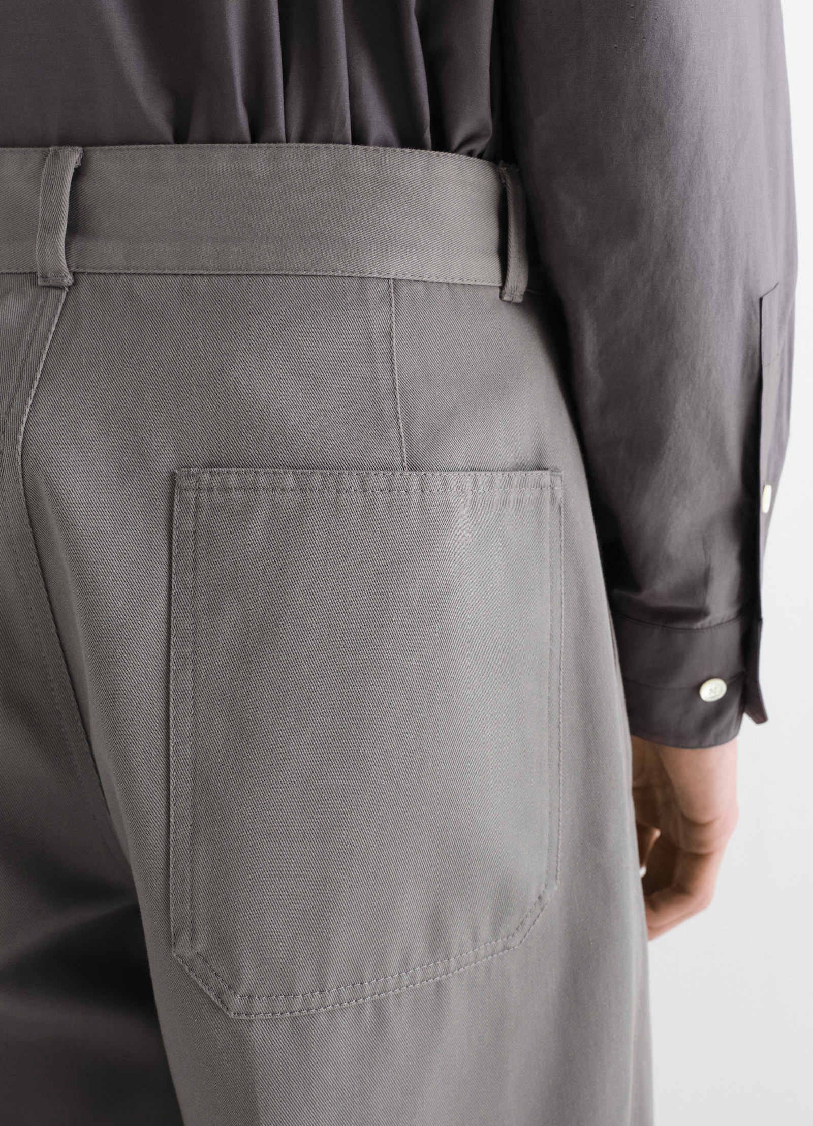 Barrel hose aus poly-baumwoll-twill, in grau, von einem model getragen, nahaufnahme von hinten, taschen sichtbar