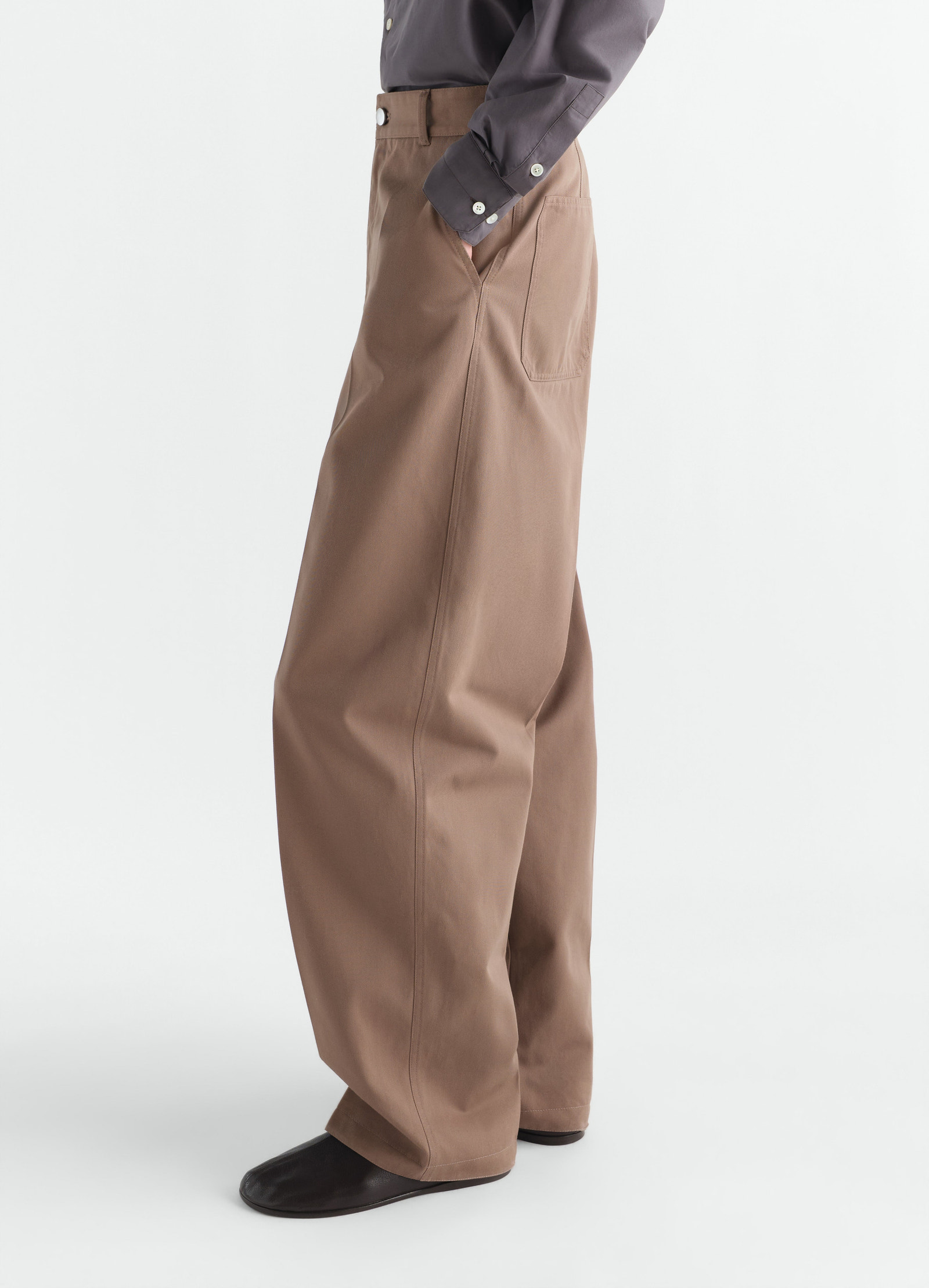 Barrel hose aus poly-baumwoll-twill, in braun, von einem model getragen, seitenansicht, taschen sichtbar, knöpfe sichtbar