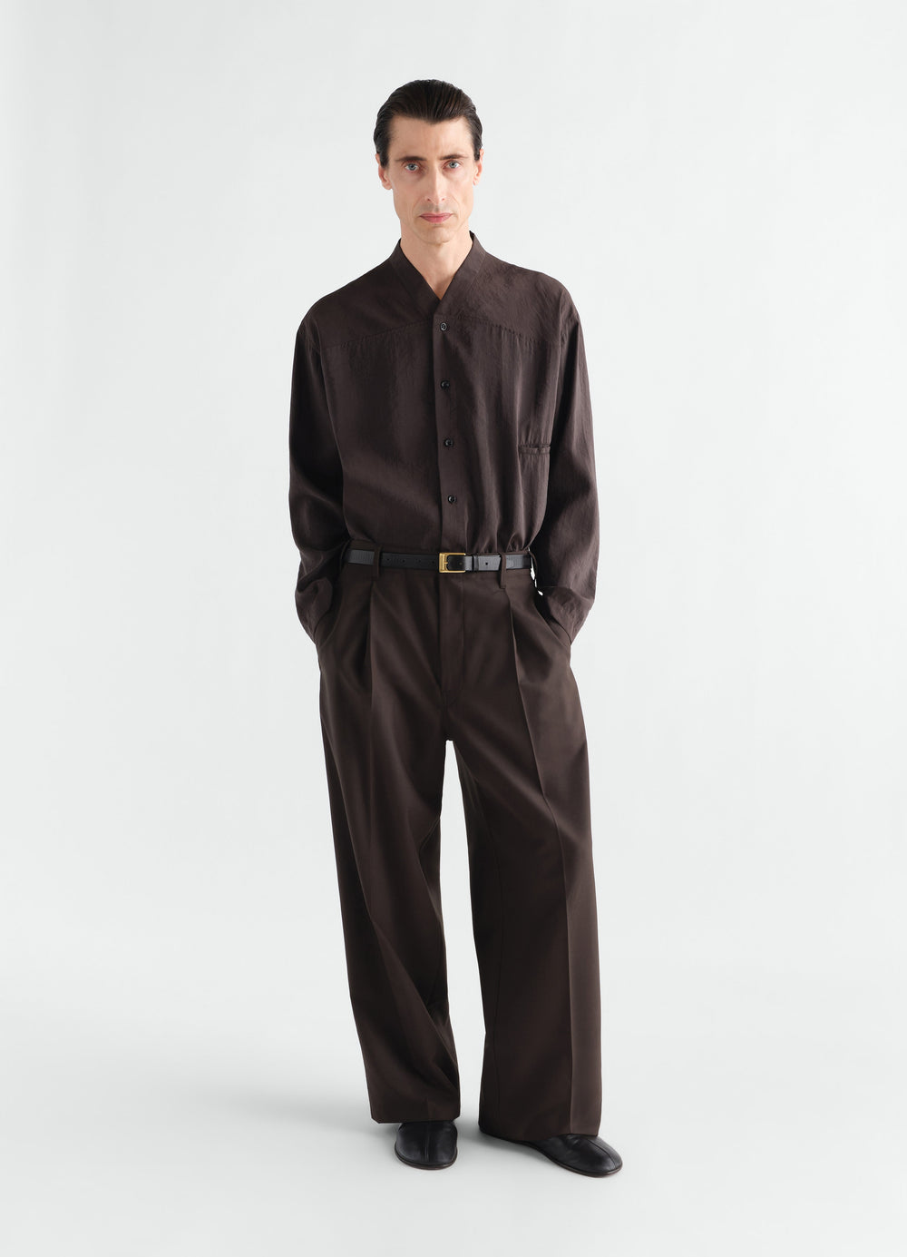 Pantalon tailleur à pli simple en laine mélangée tropicale, coloris marron, porté par un mannequin, vue de face, ceinture visible, plis visibles