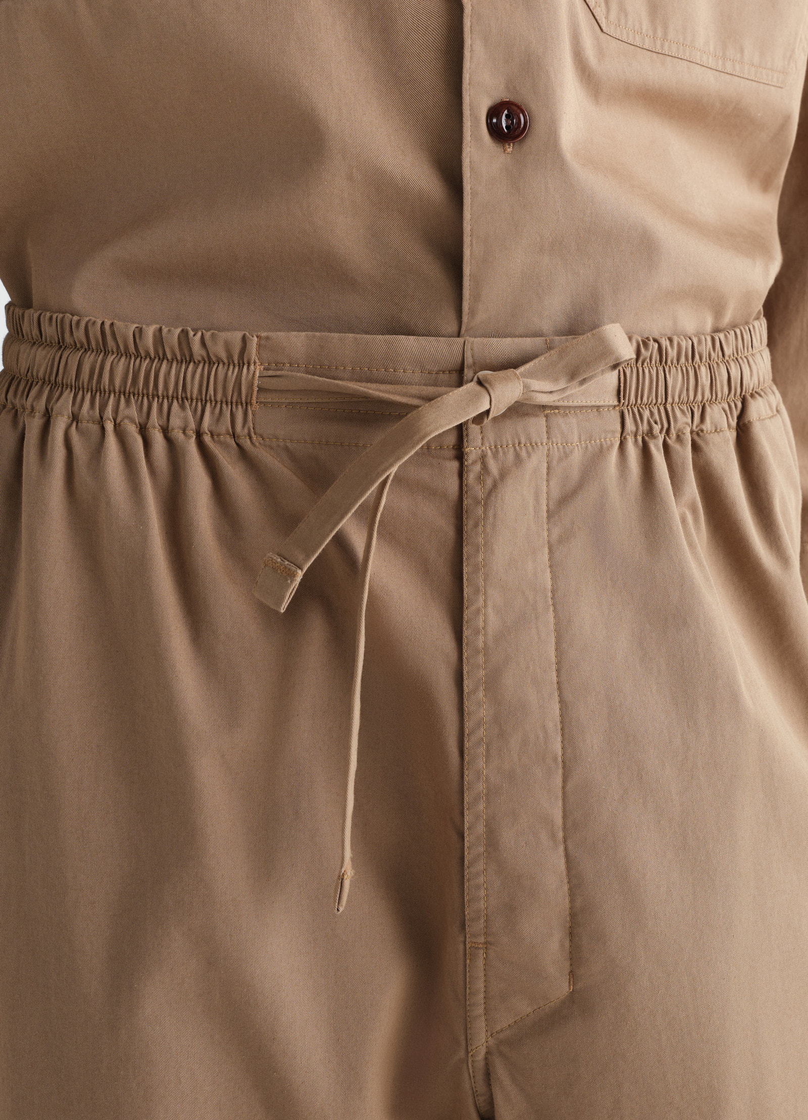 Light brown cotton twill pyjama pants with elastic waist and tied belt detail worn by a model lemaire