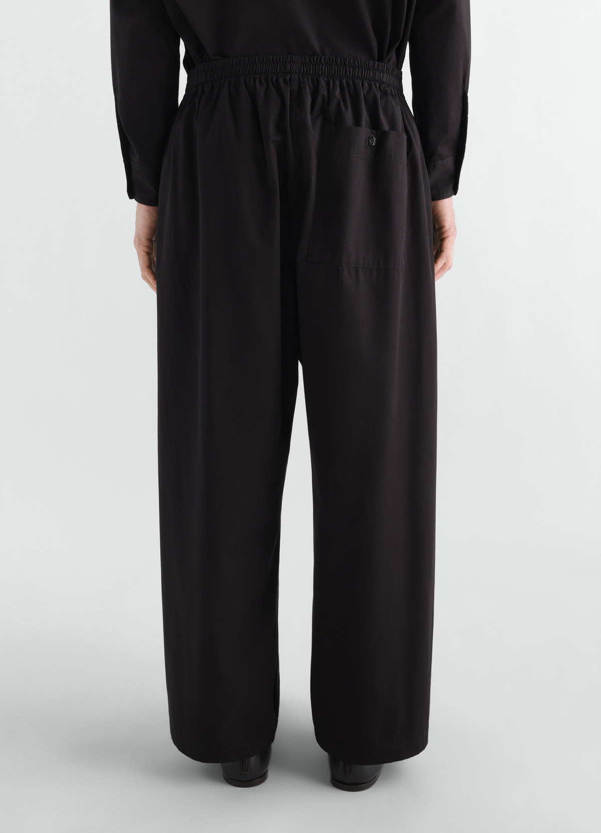 Pyjama pants in black cotton twill with elastic waist and back pocket worn by model back view lemaire