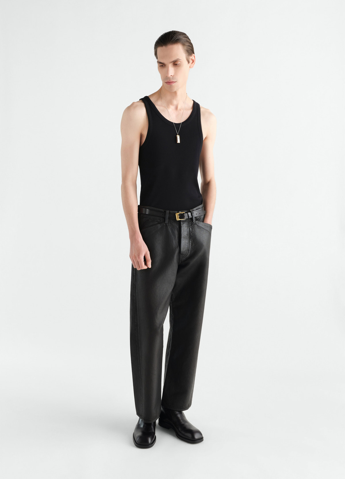 Gerade hose mit fünf taschen aus beschichtetem denim, in schwarz, von einem model getragen, vorderansicht, taschen sichtbar