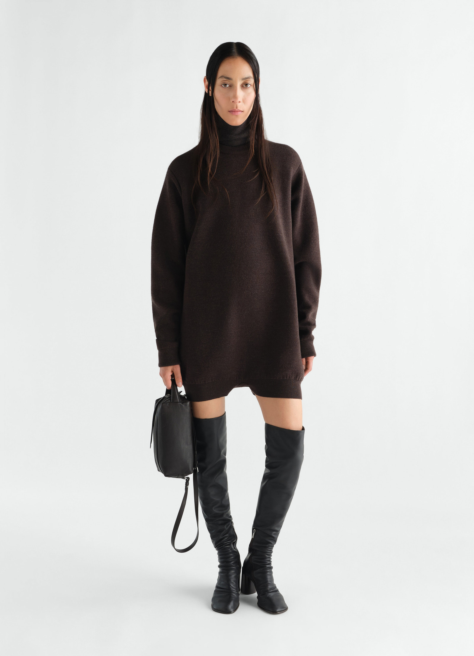 Relaxed brown felted merino wool jumpsuit by lemaire worn by model with black leather boots and bag front view