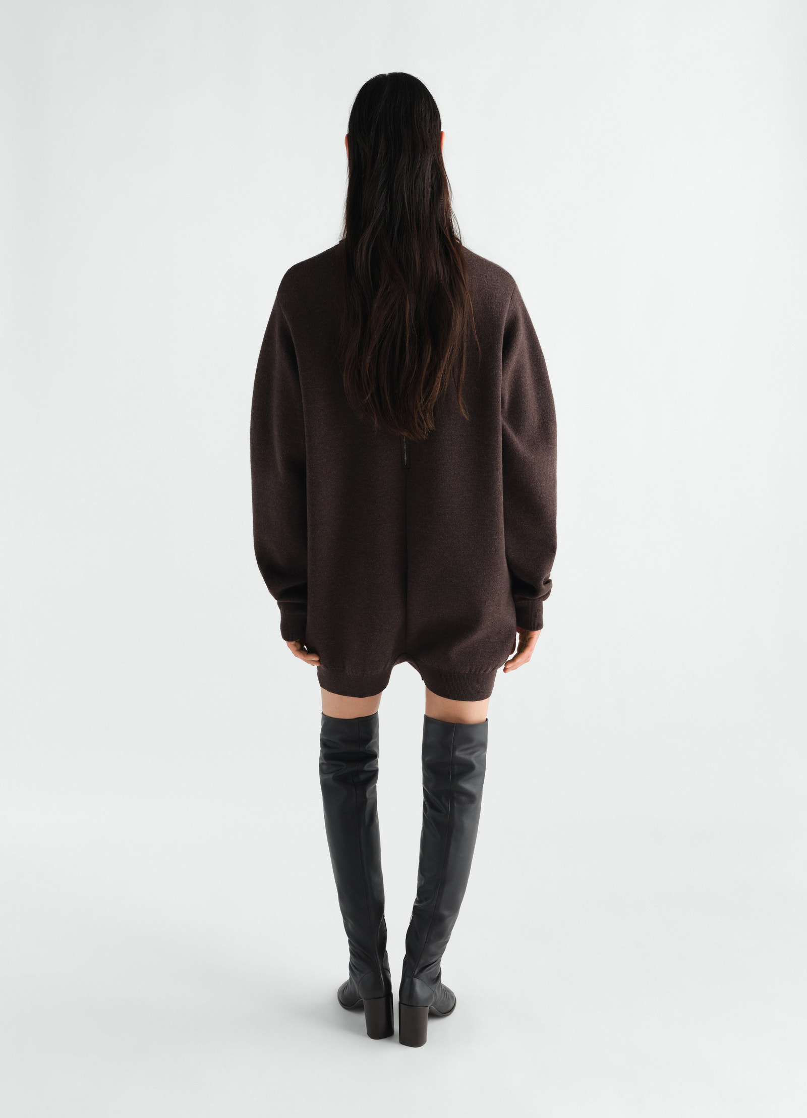 Relaxed brown felted merino wool jumpsuit by lemaire worn by model back view with black leather thigh-high boots