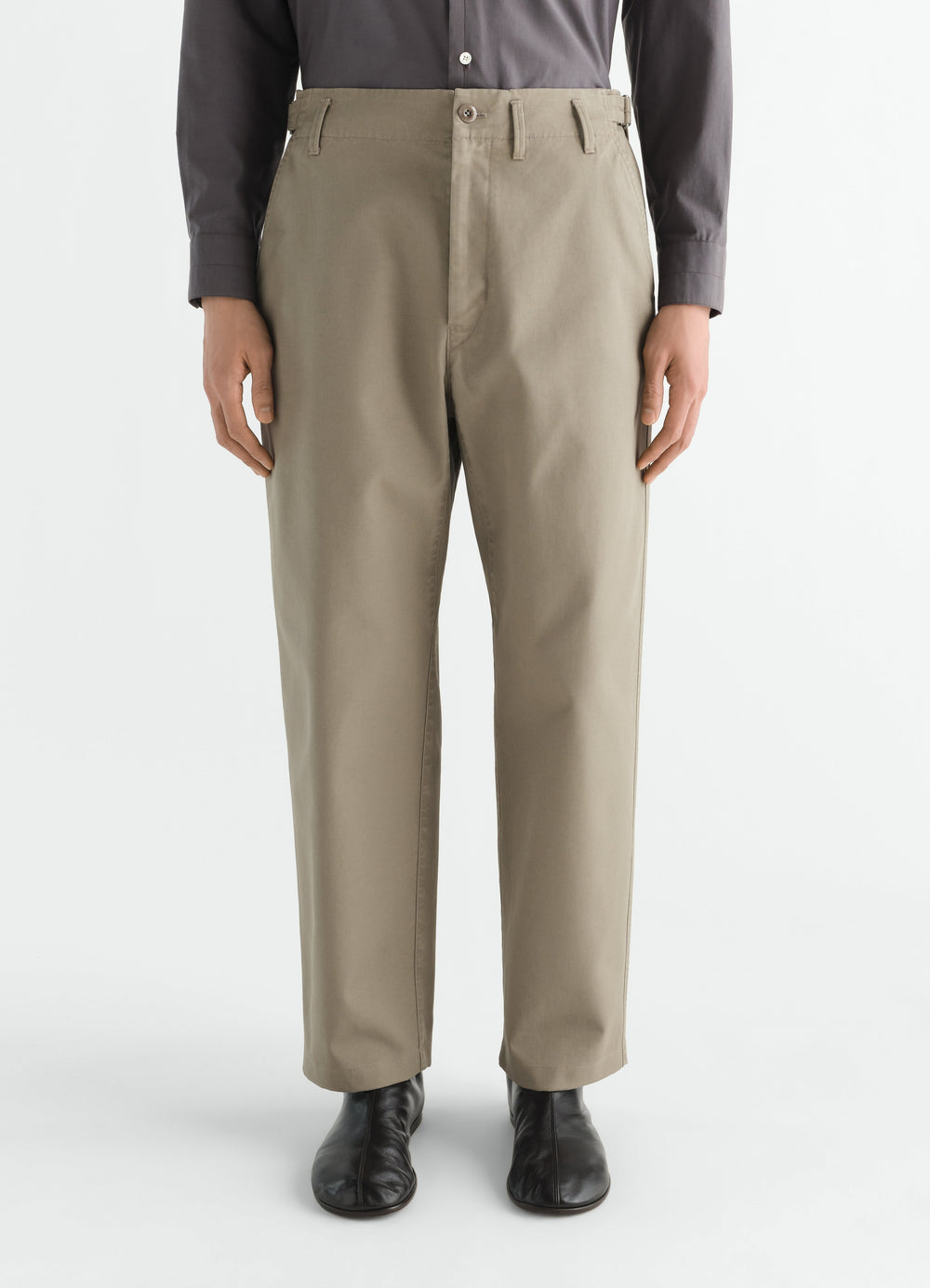 Tapered heavy cotton twill beige pants by LEMAIRE worn by model front with black boots and dark shirt