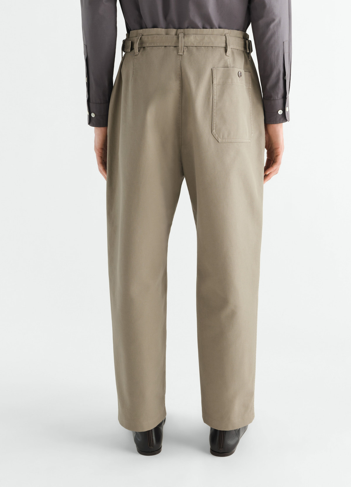 Tapered beige heavy cotton twill pants with back pocket and belt detail worn by model lemaire back view