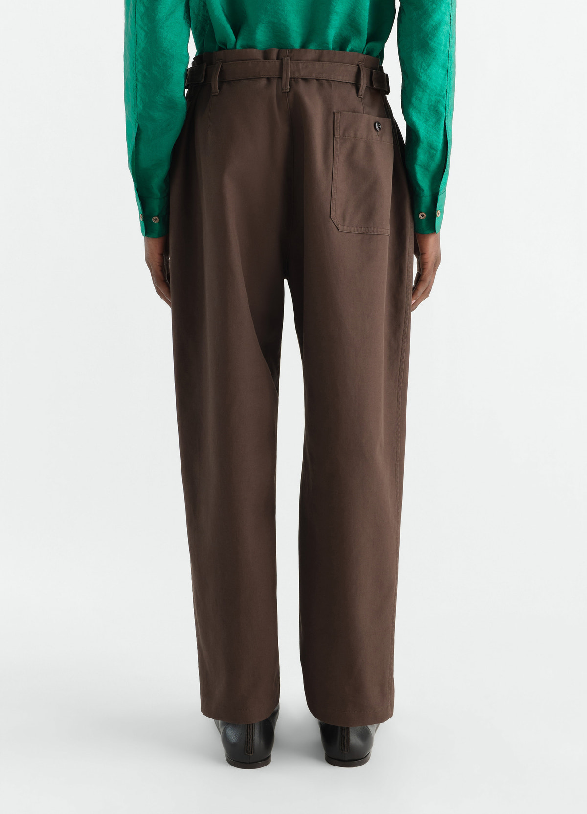 Tapered brown heavy cotton twill pants lemaire worn by model back view with green shirt and black shoes