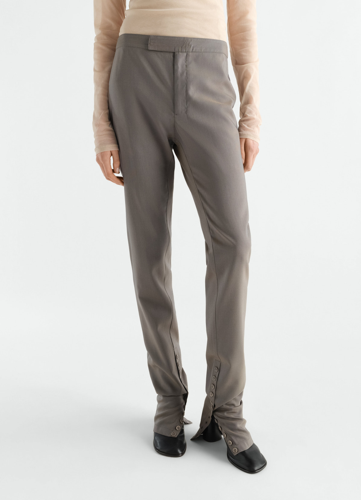 Pantalon tailleur en toile de laine et mohair avec guêtres intégrées, coloris gris, porté par un mannequin, vue de face, boutons visibles