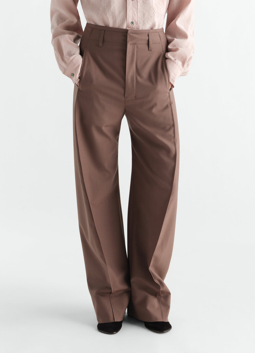 Pantalon baggy en laine mélangée tropicale, coloris marron, porté par un mannequin, vue de face, poches visibles, passants de ceinture visibles