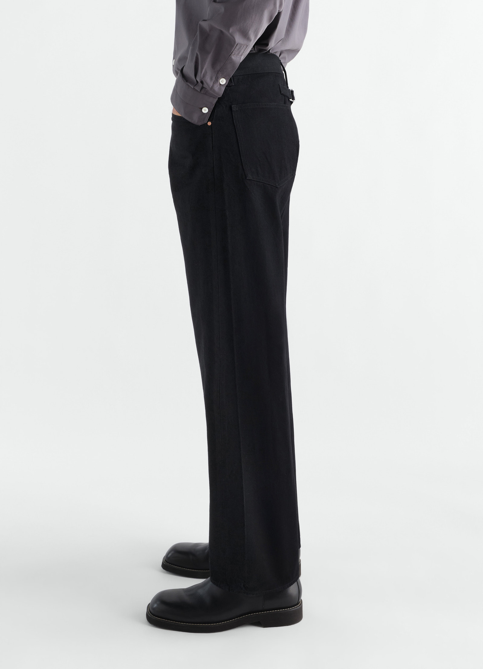 Straight five-pocket black selvedge denim pants by lemaire worn by model side view